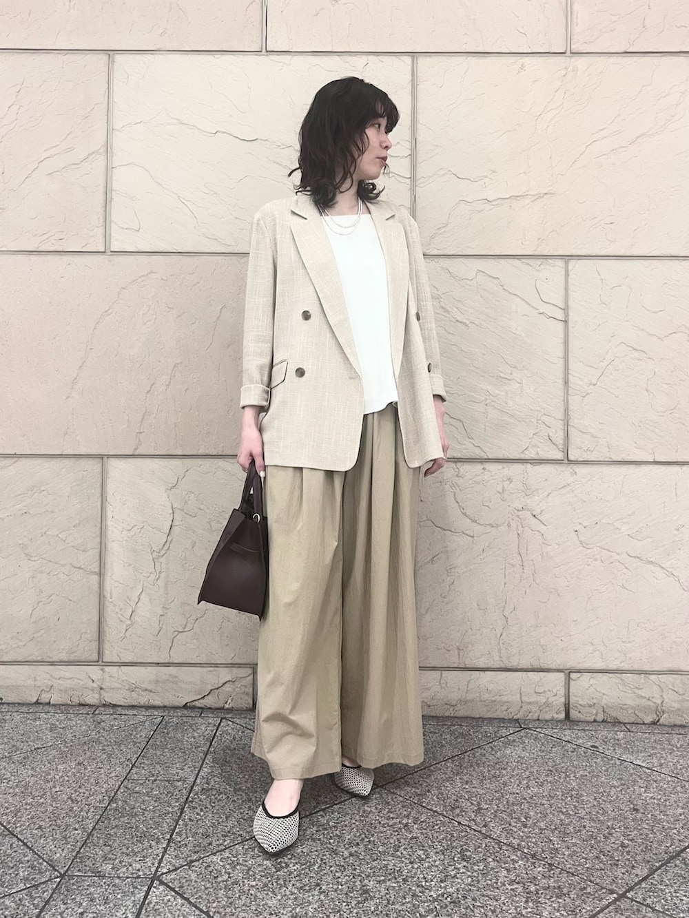 ベージュ系のその他パンツ、ベージュ系のその他アウター、ブラック系のパンプスを着用したレディースの春コーディネートの2枚目の写真