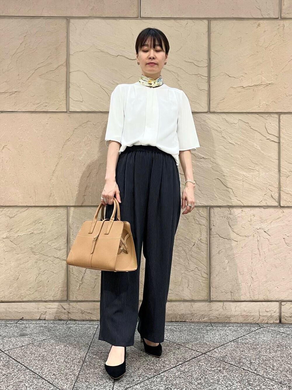 ブラック系のパンプス、ホワイト系のシャツ/ブラウス、イエロー系のトートバッグを着用したレディースの夏コーディネートの3枚目の写真