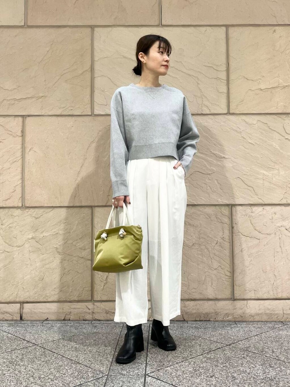ブラック系のブーツ、グリーン系のトートバッグ、ホワイト系のその他パンツを着用したレディースの冬コーディネートの2枚目の写真