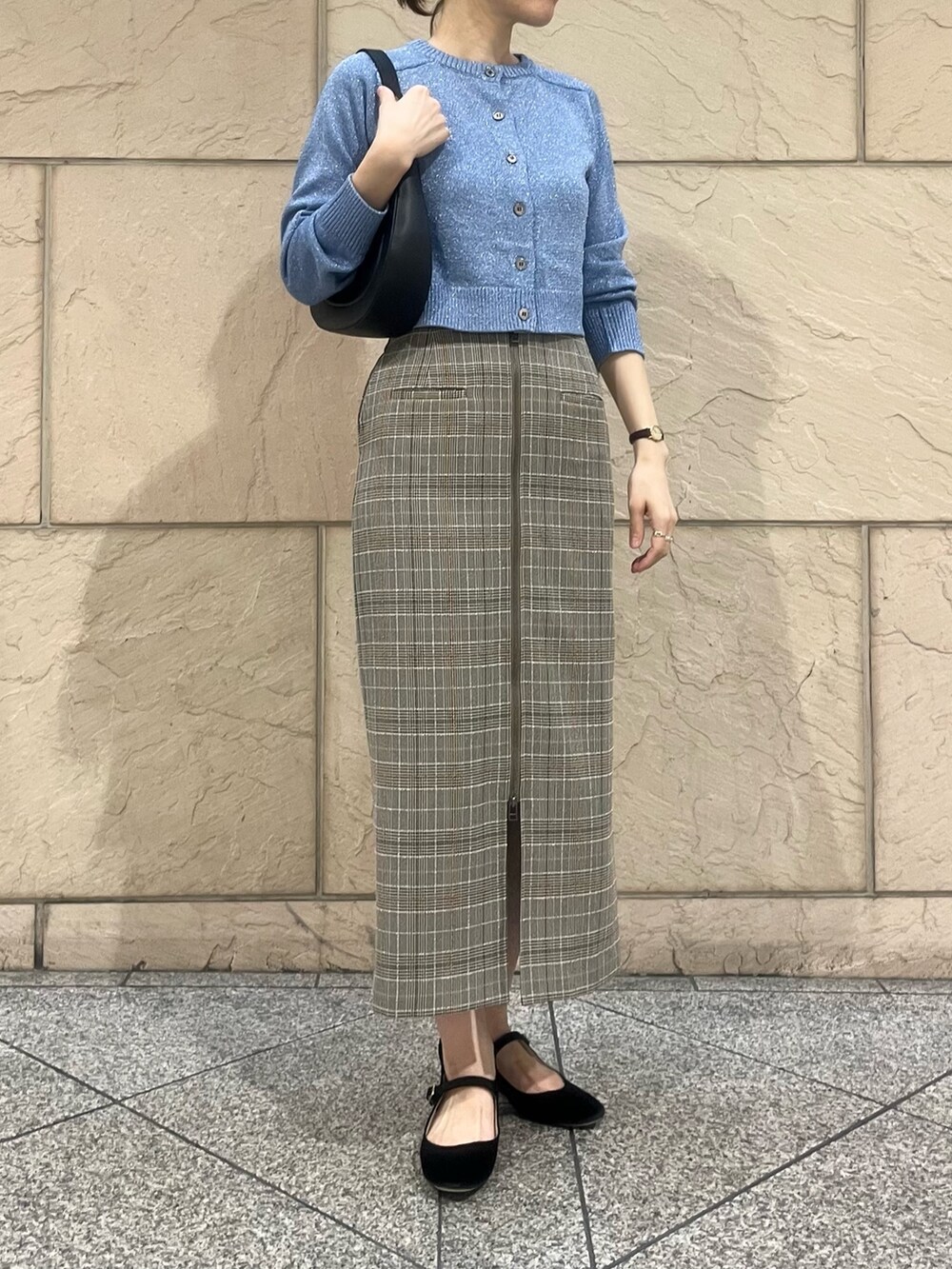 ブルー系のニット/セーター、ブラウン系のスカート、ブラック系のショルダーバッグを着用したレディースの秋コーディネートの2枚目の写真