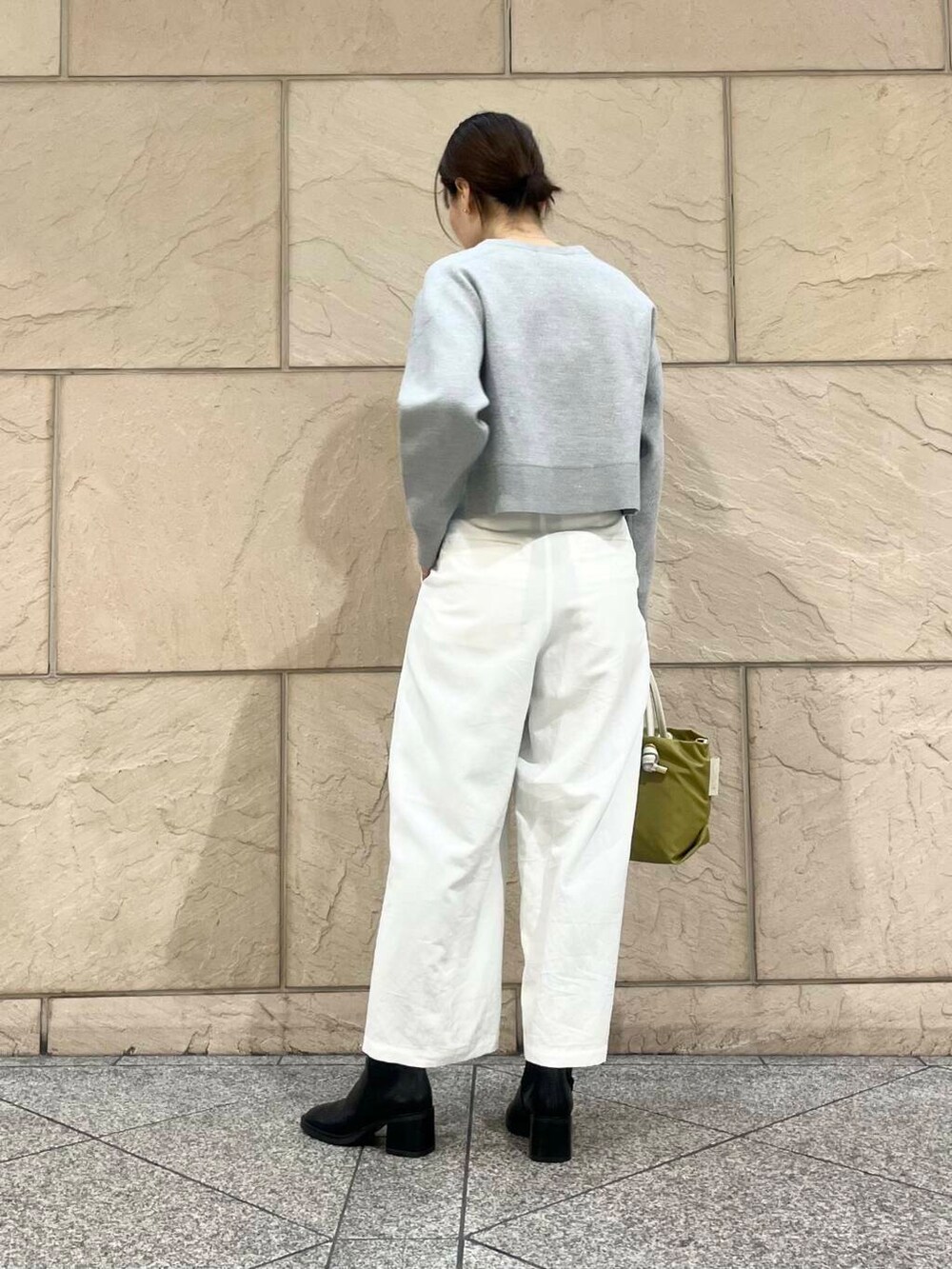 ブラック系のブーツ、グリーン系のトートバッグ、ホワイト系のその他パンツを着用したレディースの冬コーディネートの3枚目の写真