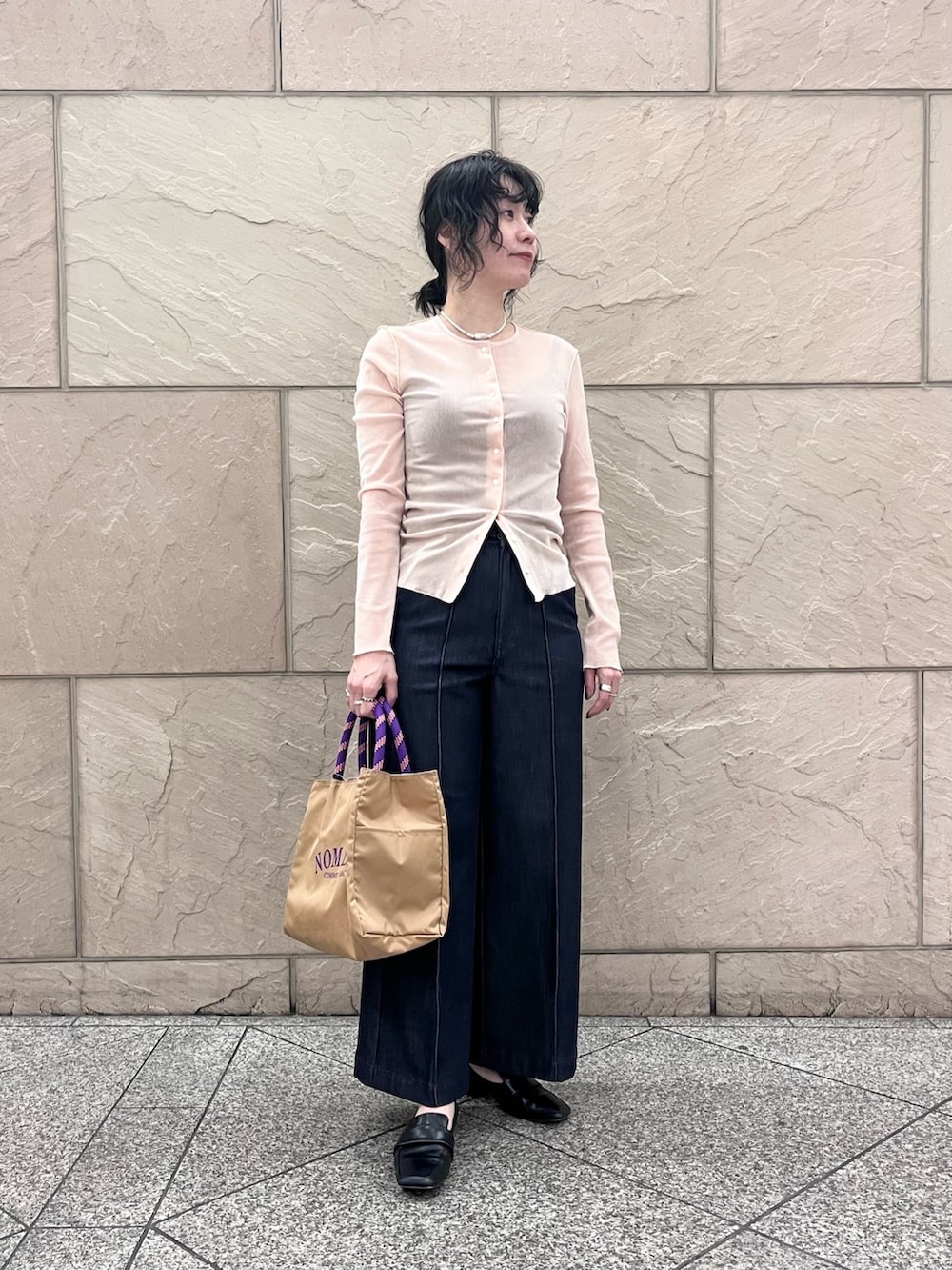 ブルー系のデニムパンツ、ベージュ系のトートバッグ、ピンク系のカーディガン/ボレロを着用したレディースの冬コーディネートの2枚目の写真