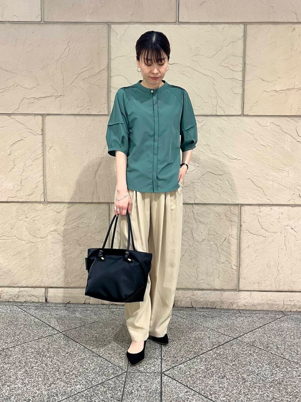 ブラック系のパンプス、ブラック系のトートバッグ、グリーン系のシャツ/ブラウスを着用したレディースの春コーディネートの2枚目の写真