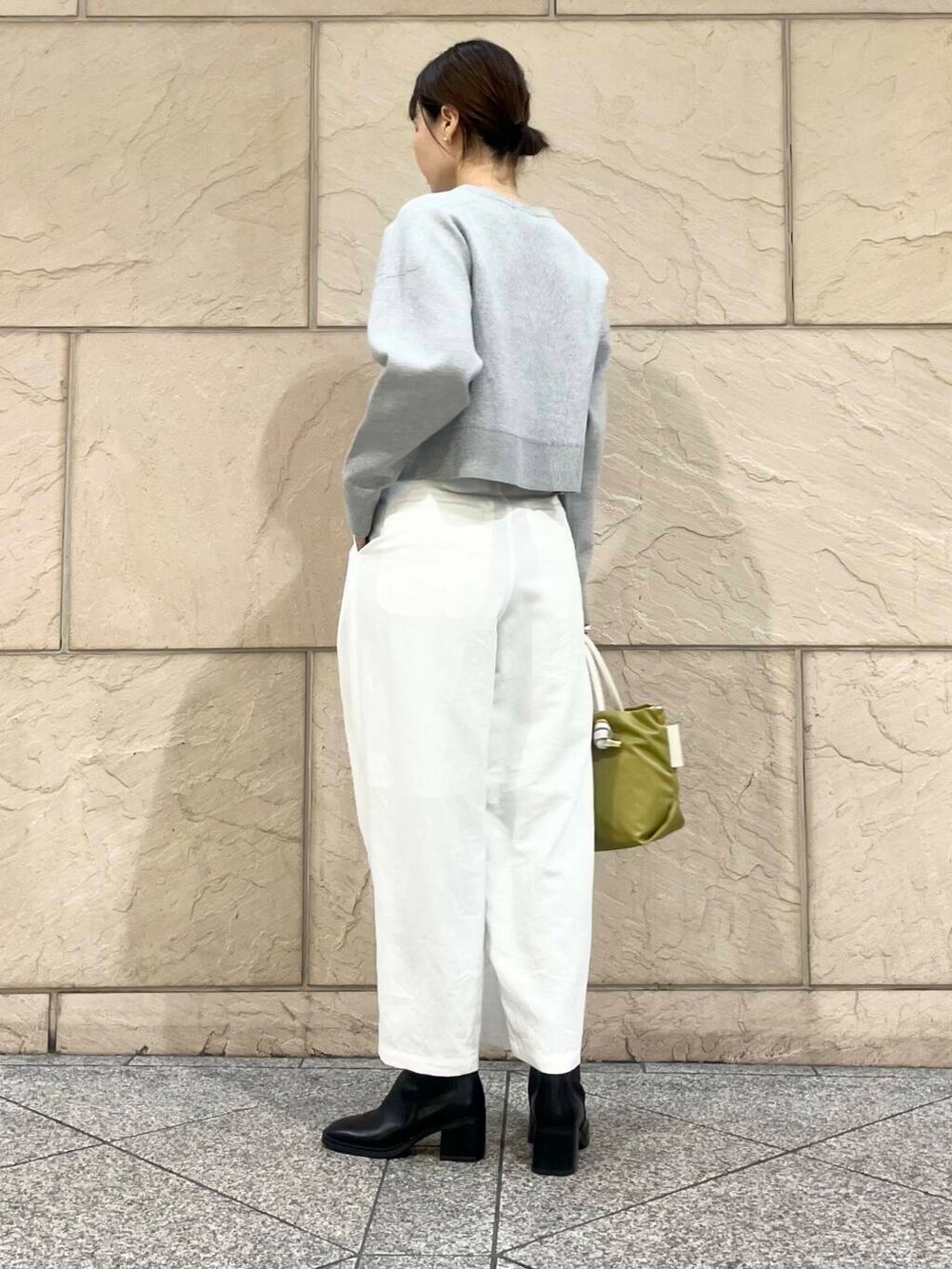 ブラック系のブーツ、グリーン系のトートバッグ、ホワイト系のその他パンツを着用したレディースの冬コーディネートの5枚目の写真