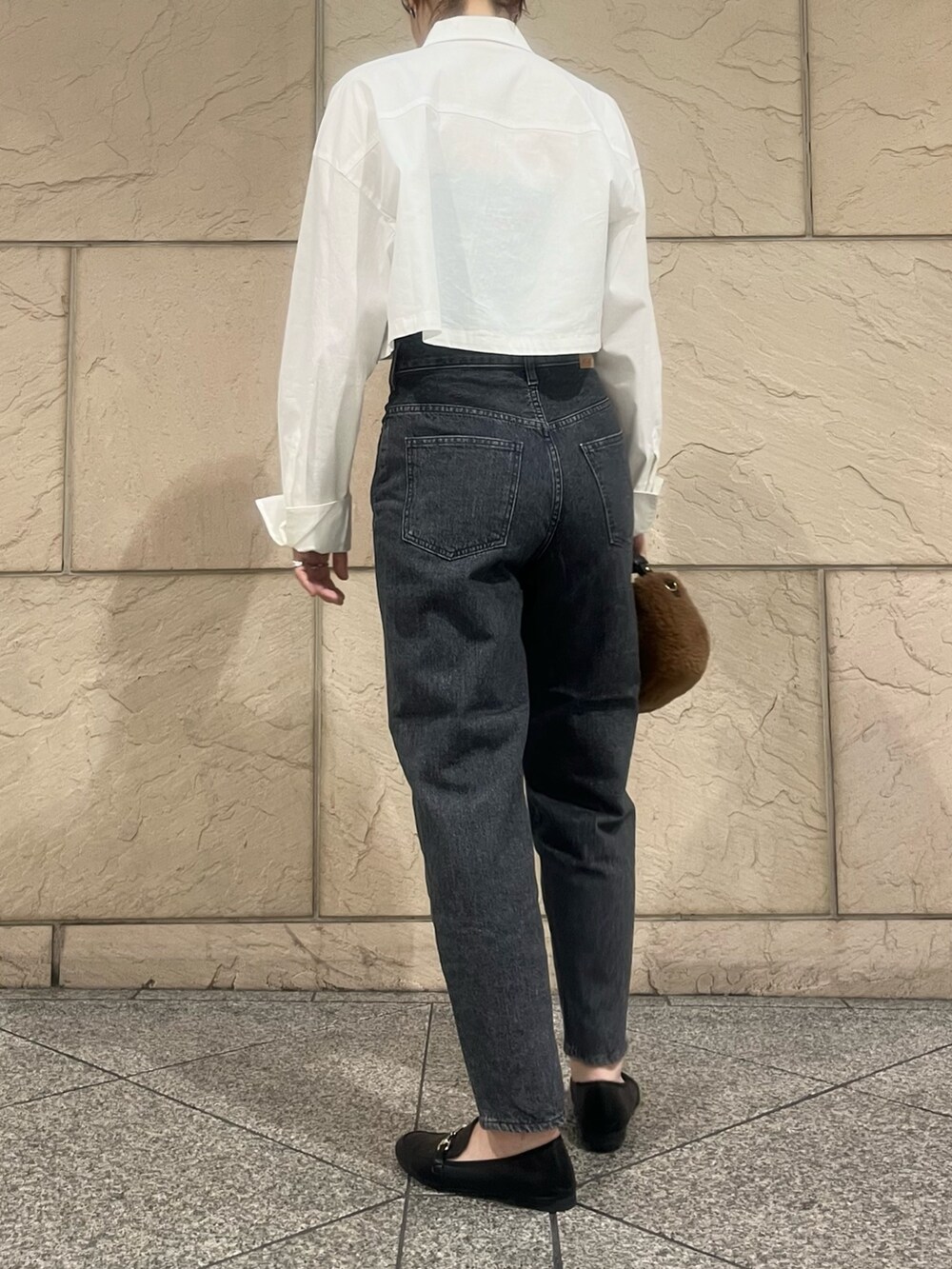 グレー系のデニムパンツ、ブラック系のローファー、ブラウン系のバッグを着用したレディースの夏コーディネートの2枚目の写真