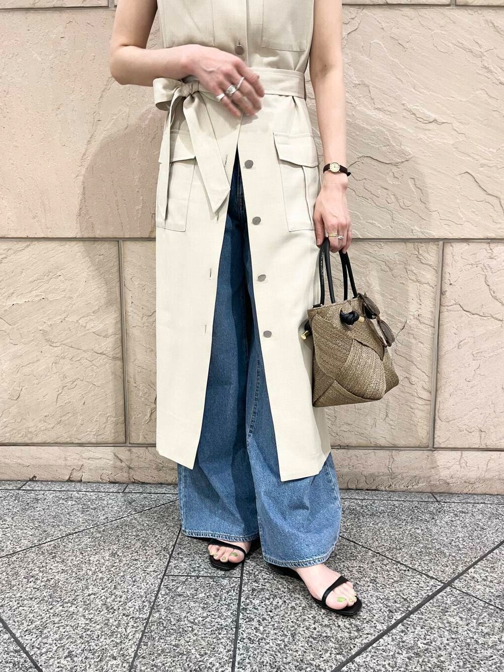 ベージュ系のワンピース、ブルー系のデニムパンツ、ベージュ系のネックレスを着用したレディースの春コーディネートの4枚目の写真