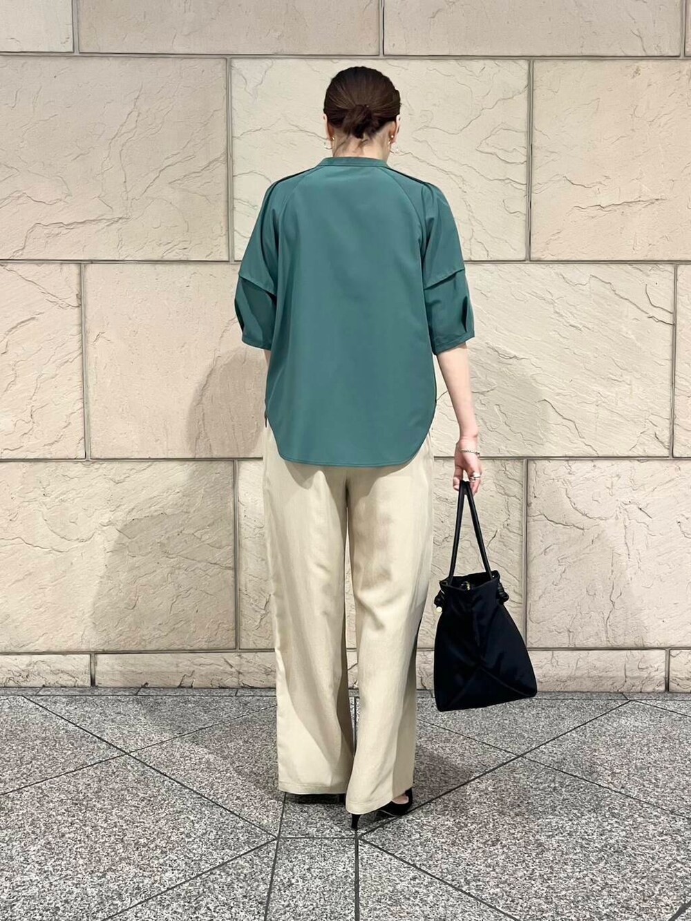 ブラック系のパンプス、ブラック系のトートバッグ、グリーン系のシャツ/ブラウスを着用したレディースの春コーディネートの4枚目の写真