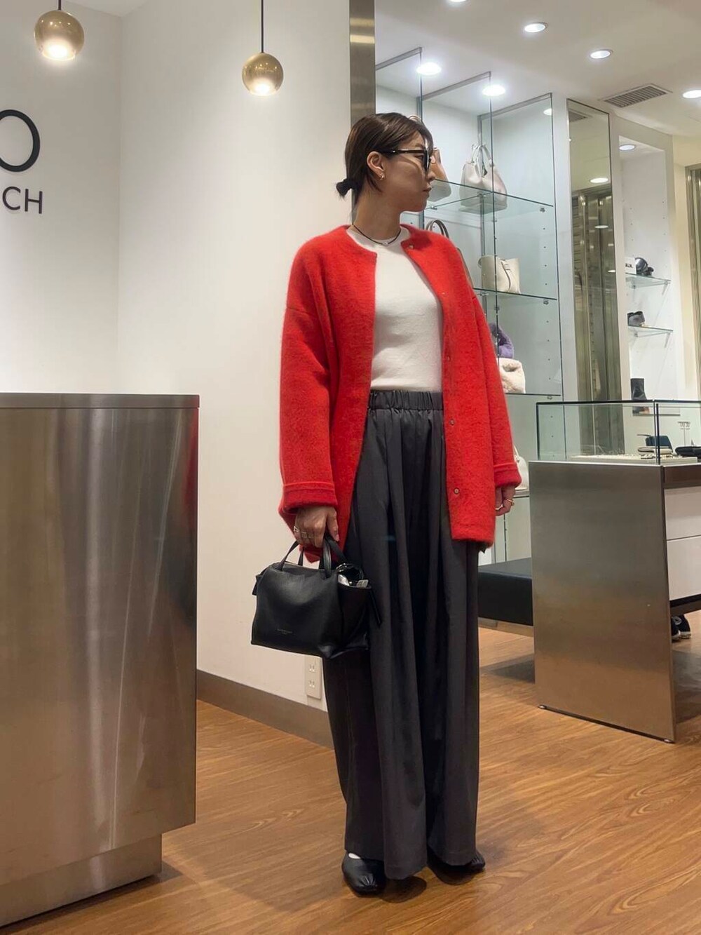 ホワイト系のTシャツ/カットソー、グレー系のその他パンツ、ブラック系のハンドバッグを着用したレディースの秋コーディネートの2枚目の写真