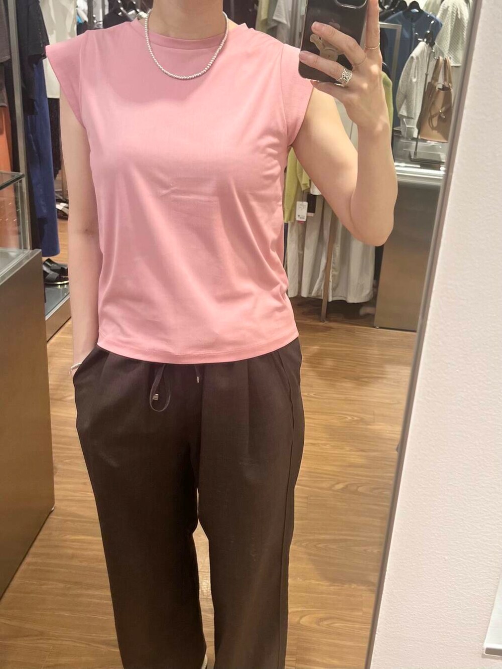 ピンク系のTシャツ/カットソー、ブラウン系のその他パンツ、シルバー系のネックレスを着用したレディースの夏コーディネートの3枚目の写真