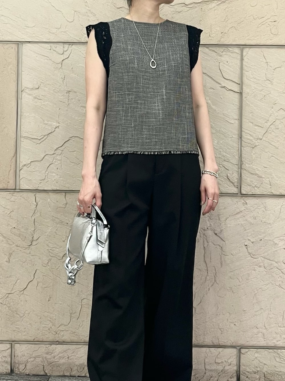 ブラック系のシャツ/ブラウス、シルバー系のハンドバッグ、ブラック系のサンダルを着用したレディースの夏コーディネートの4枚目の写真