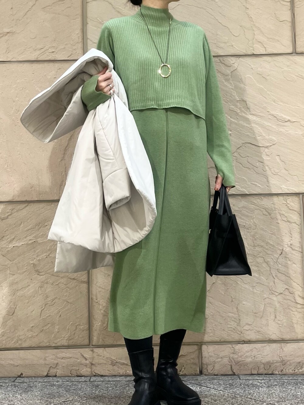 グリーン系のワンピース、ベージュ系のダウンジャケット/コート、ゴールド系のネックレスを着用したレディースの冬コーディネートの5枚目の写真