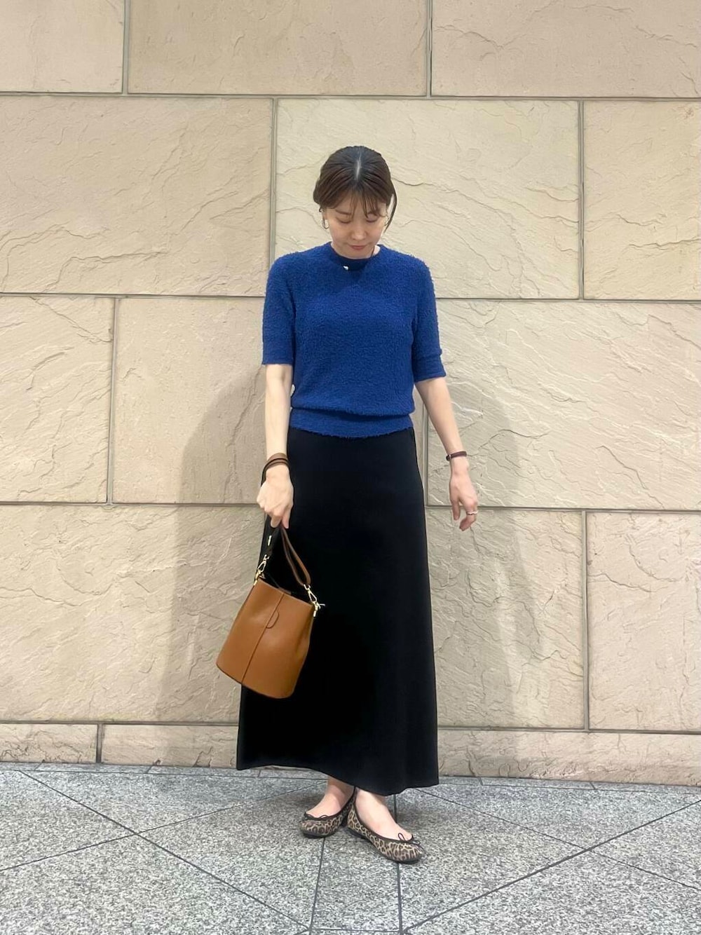 ブルー系のニット/セーター、ブラウン系のショルダーバッグ、ブラック系のスカートを着用したレディースの秋コーディネートの3枚目の写真