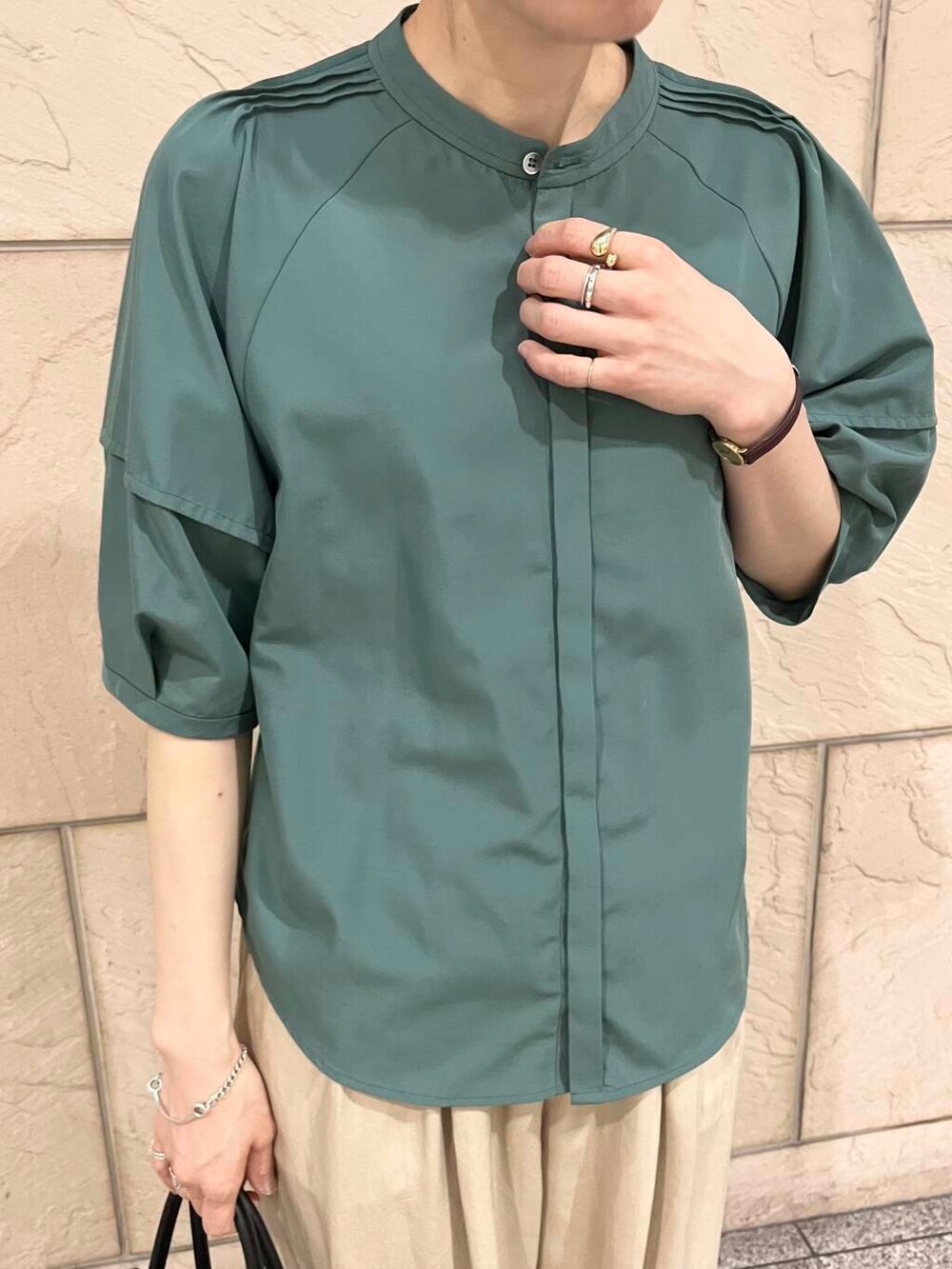 ブラック系のパンプス、ブラック系のトートバッグ、グリーン系のシャツ/ブラウスを着用したレディースの春コーディネートの6枚目の写真