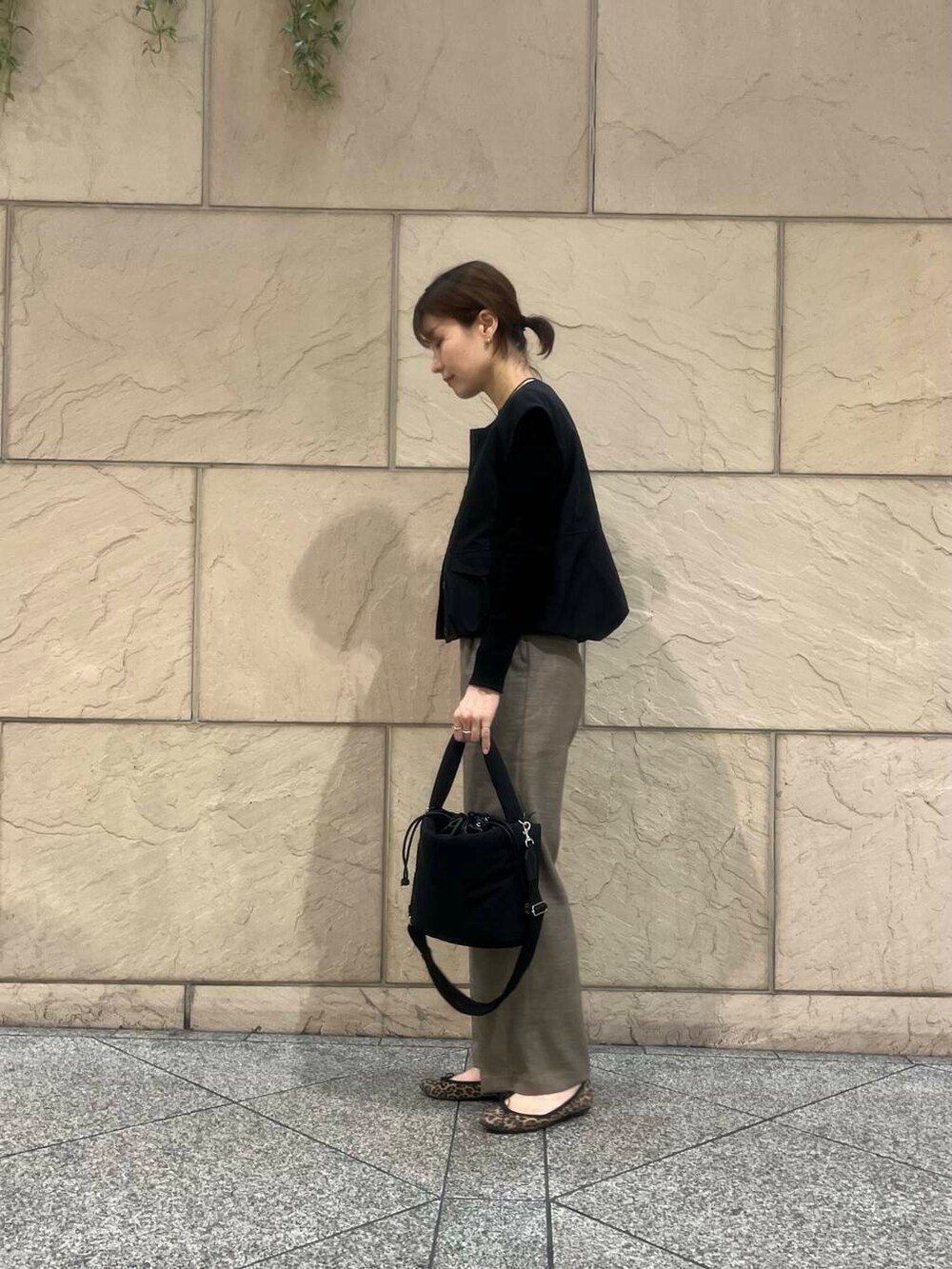 ベージュ系のその他パンツ、ブラック系のTシャツ/カットソー、ブラック系のベストを着用したレディースの秋コーディネートの3枚目の写真