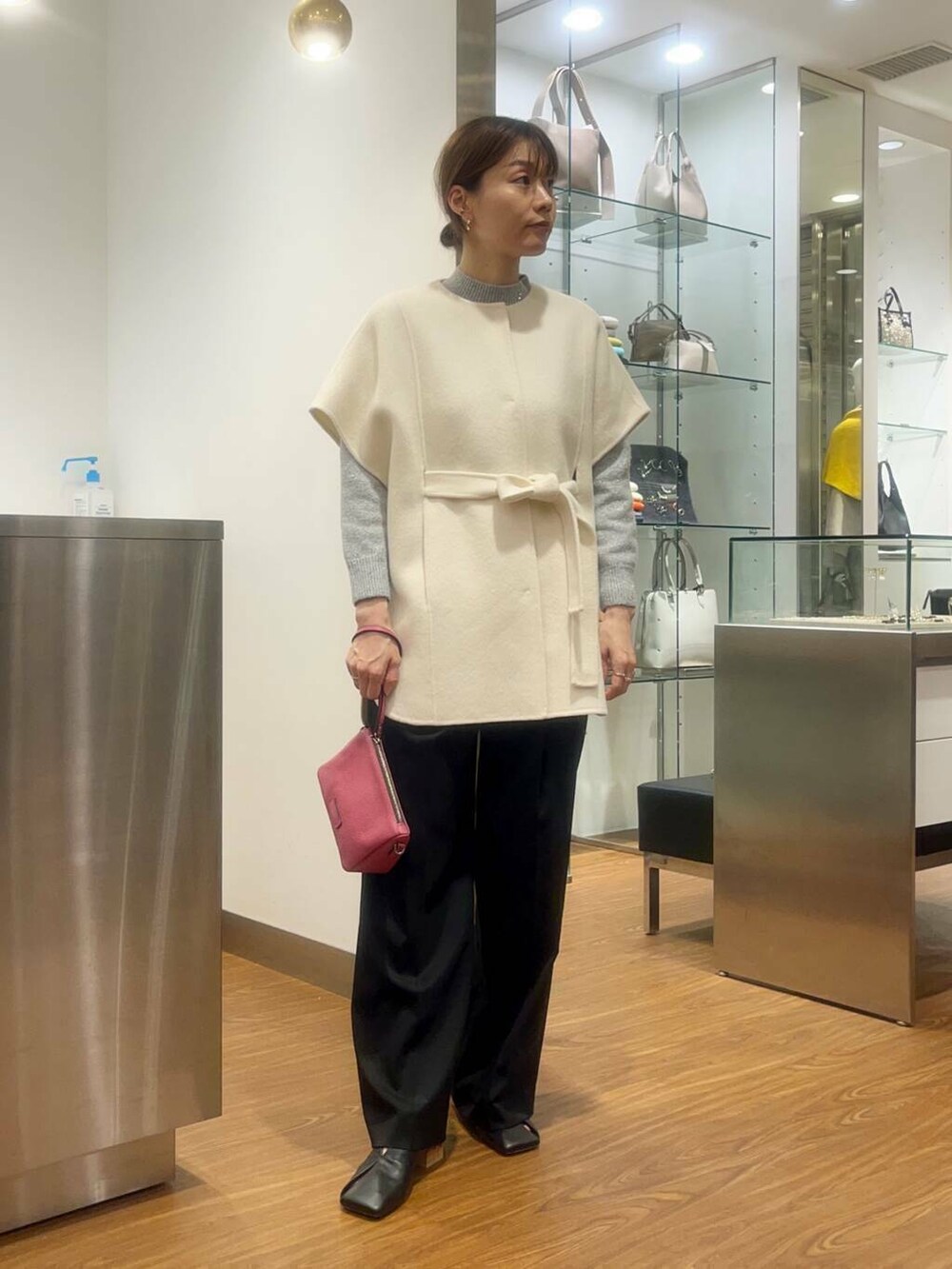 ホワイト系のポンチョ、ブラック系のその他パンツ、グレー系のニット/セーターを着用したレディースの秋コーディネートの2枚目の写真