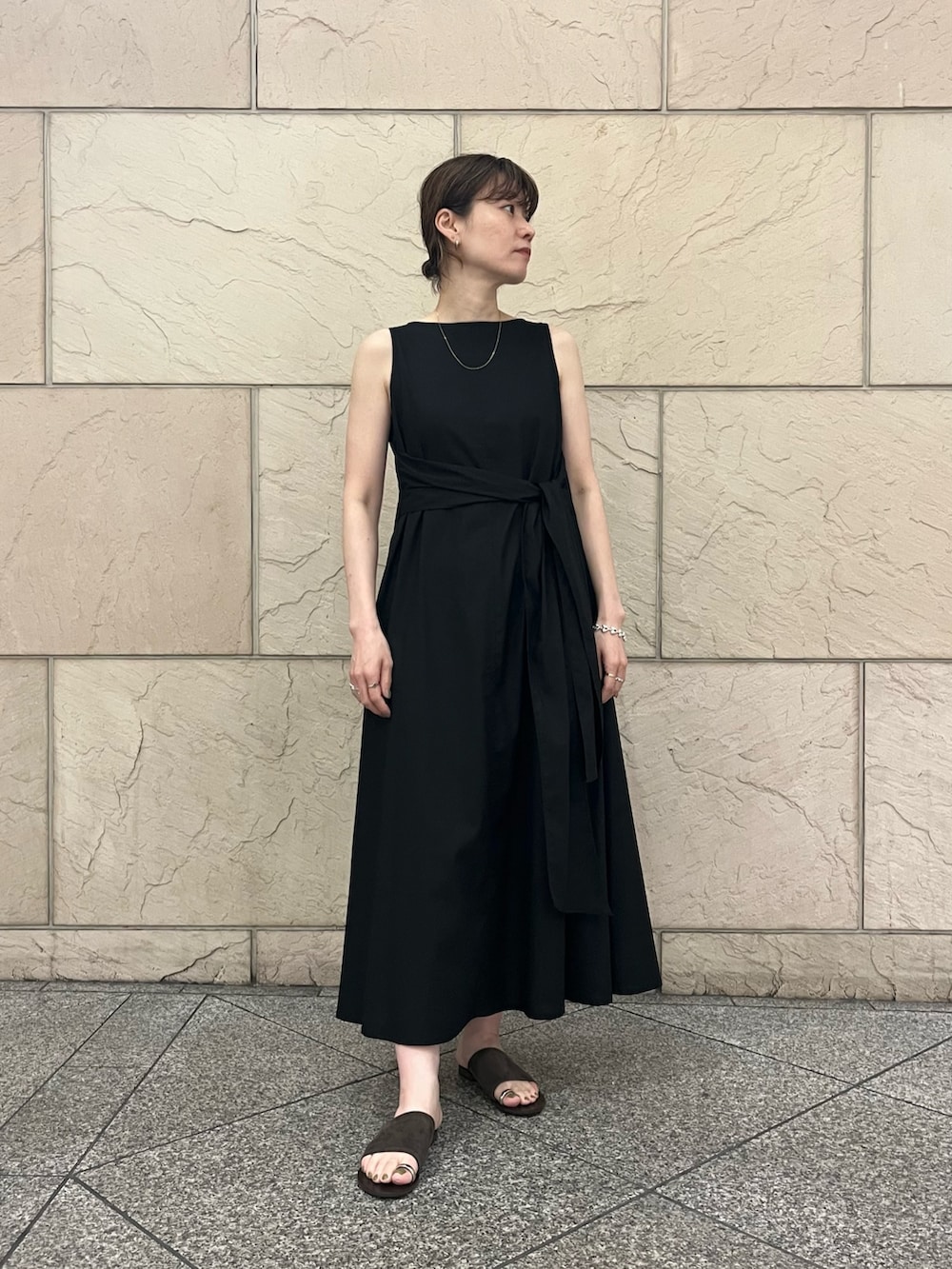 ブラック系のワンピース、オレンジ系のカーディガン/ボレロ、ブラウン系のサンダルを着用したレディースの夏コーディネートの5枚目の写真