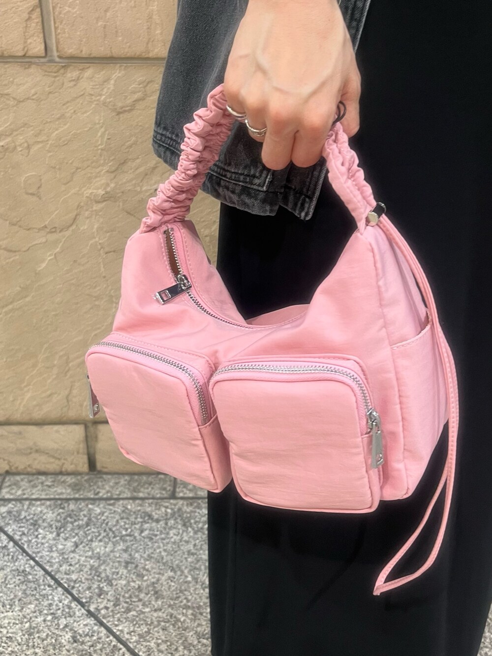 グレー系のデニムジャケット、レッド系のショルダーバッグ、ブラック系のキャミソールを着用したレディースの夏コーディネートの4枚目の写真