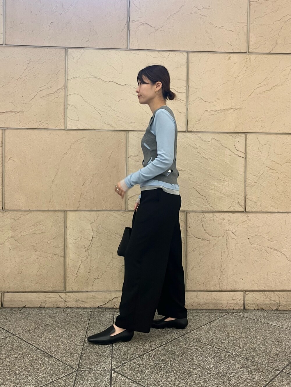 ブラック系のローファー、ブラック系のハンドバッグ、ホワイト系のニット/セーターを着用したレディースの秋コーディネートの3枚目の写真