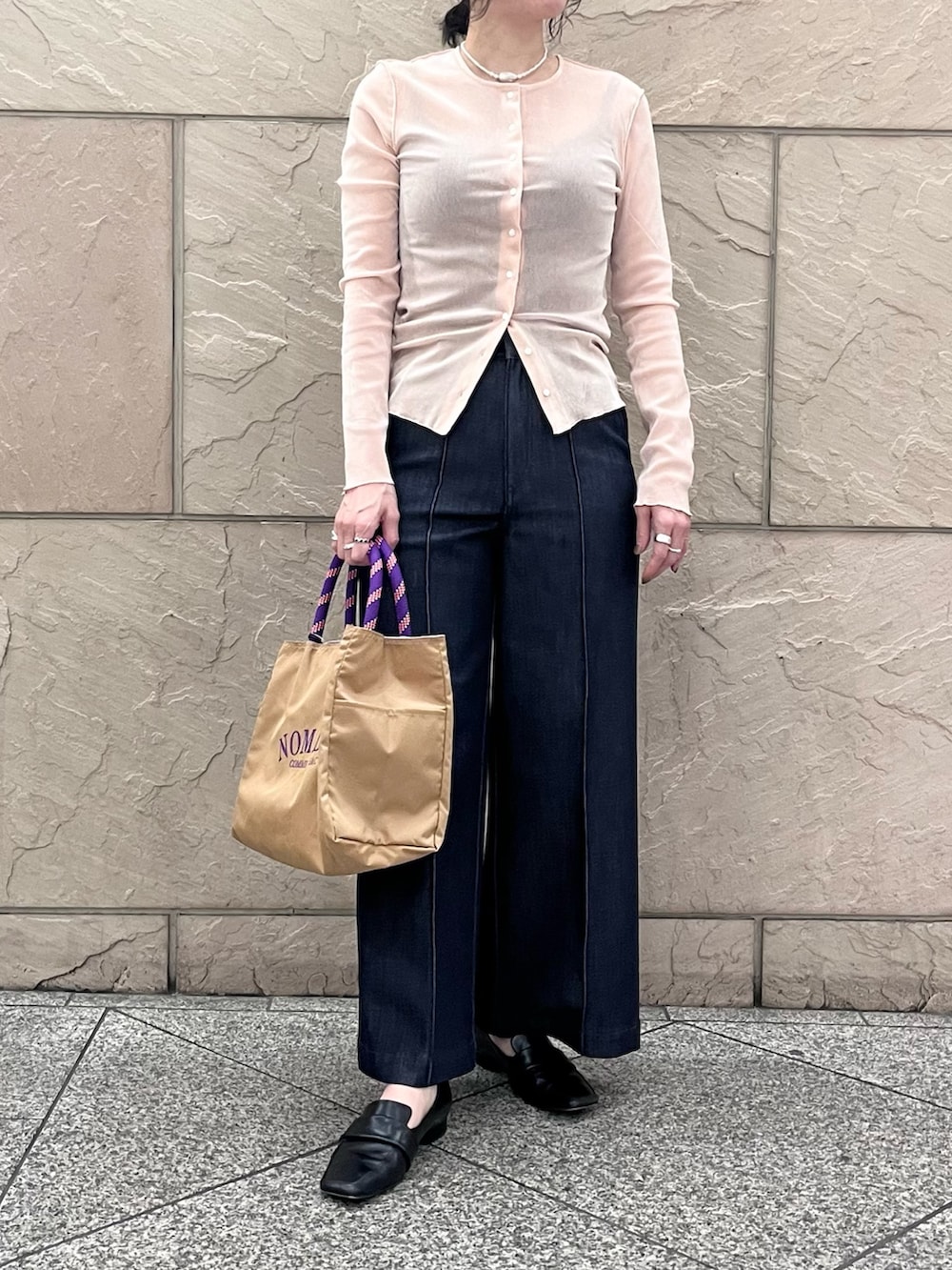 ブルー系のデニムパンツ、ベージュ系のトートバッグ、ピンク系のカーディガン/ボレロを着用したレディースの冬コーディネートの4枚目の写真