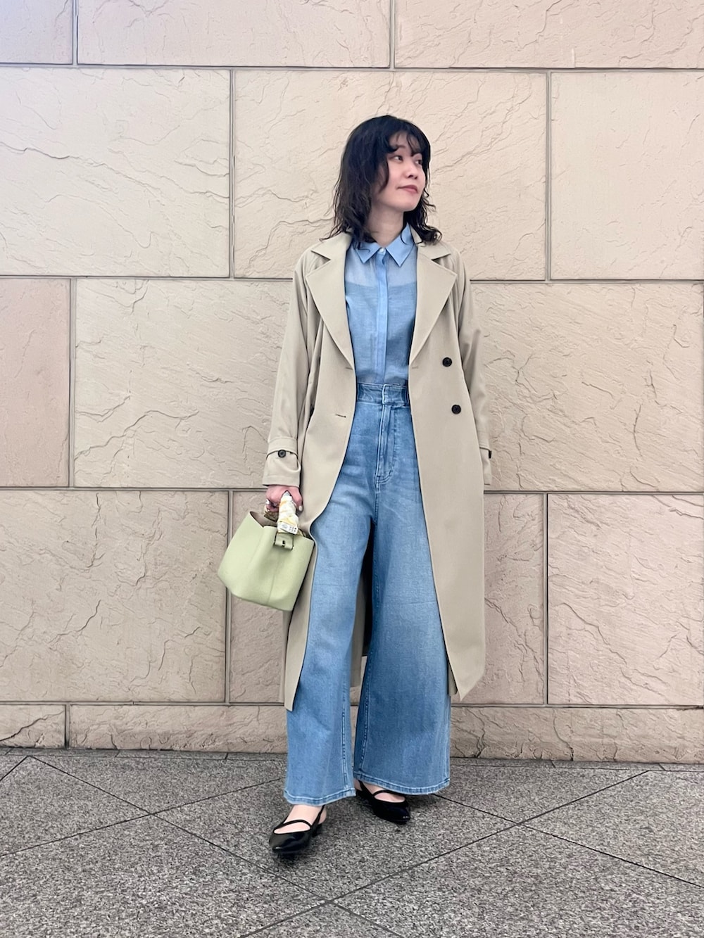 ブルー系のデニムパンツ、ベージュ系のトレンチコート、グリーン系のショルダーバッグを着用したレディースの春コーディネートの4枚目の写真