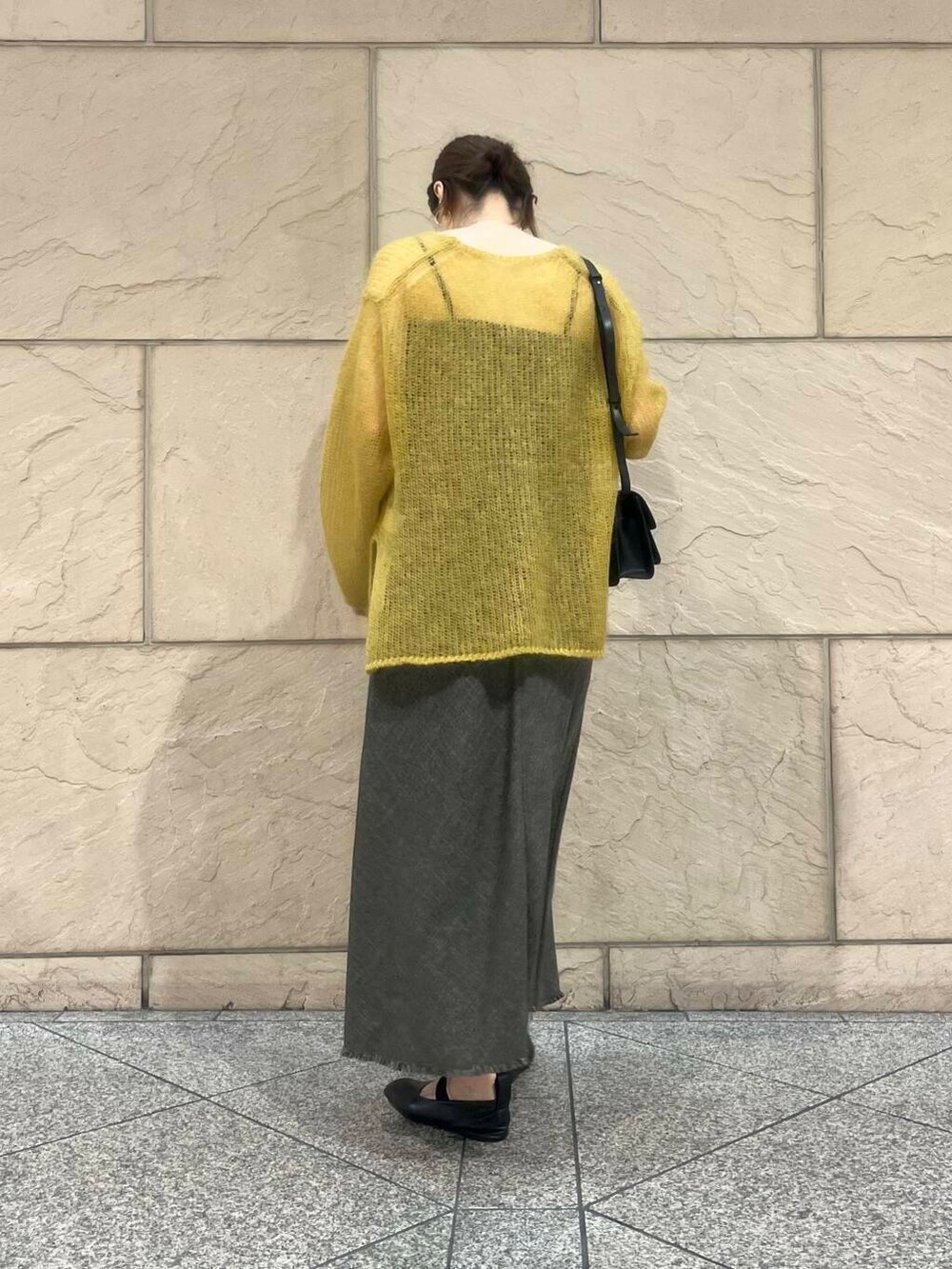 イエロー系のニット/セーター、ブラウン系のワンピース、ブラック系のショルダーバッグを着用したレディースの秋コーディネートの3枚目の写真