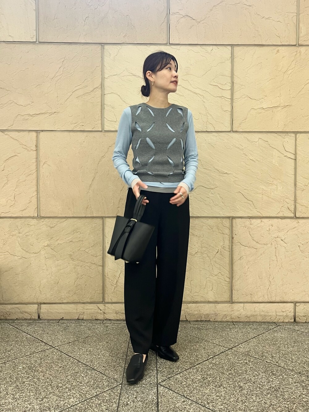 ブラック系のローファー、ブラック系のハンドバッグ、ホワイト系のニット/セーターを着用したレディースの秋コーディネートの5枚目の写真