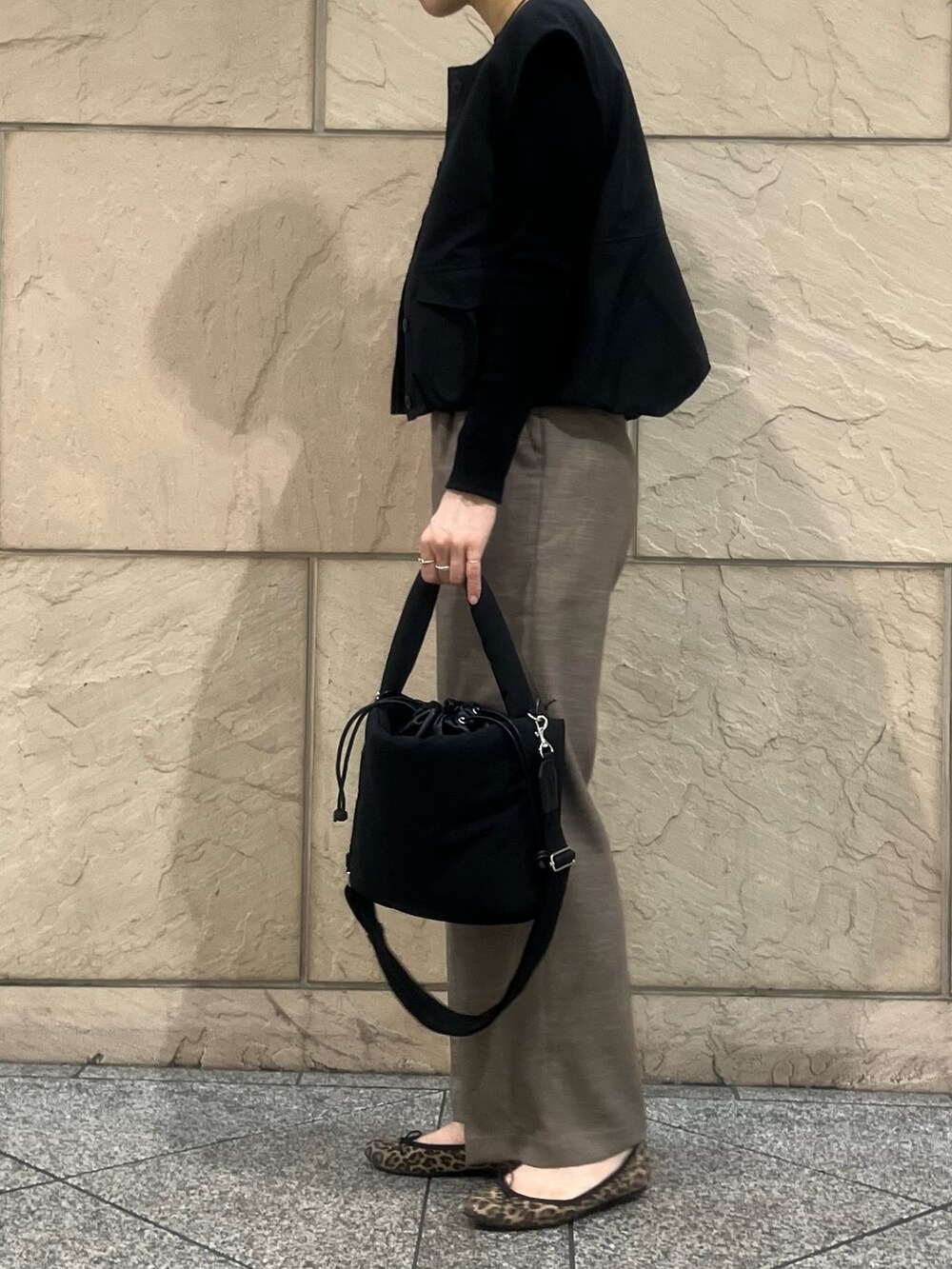 ブラック系のショルダーバッグ、ベージュ系のその他パンツ、ブラック系のベストを着用したレディースの秋コーディネートの2枚目の写真