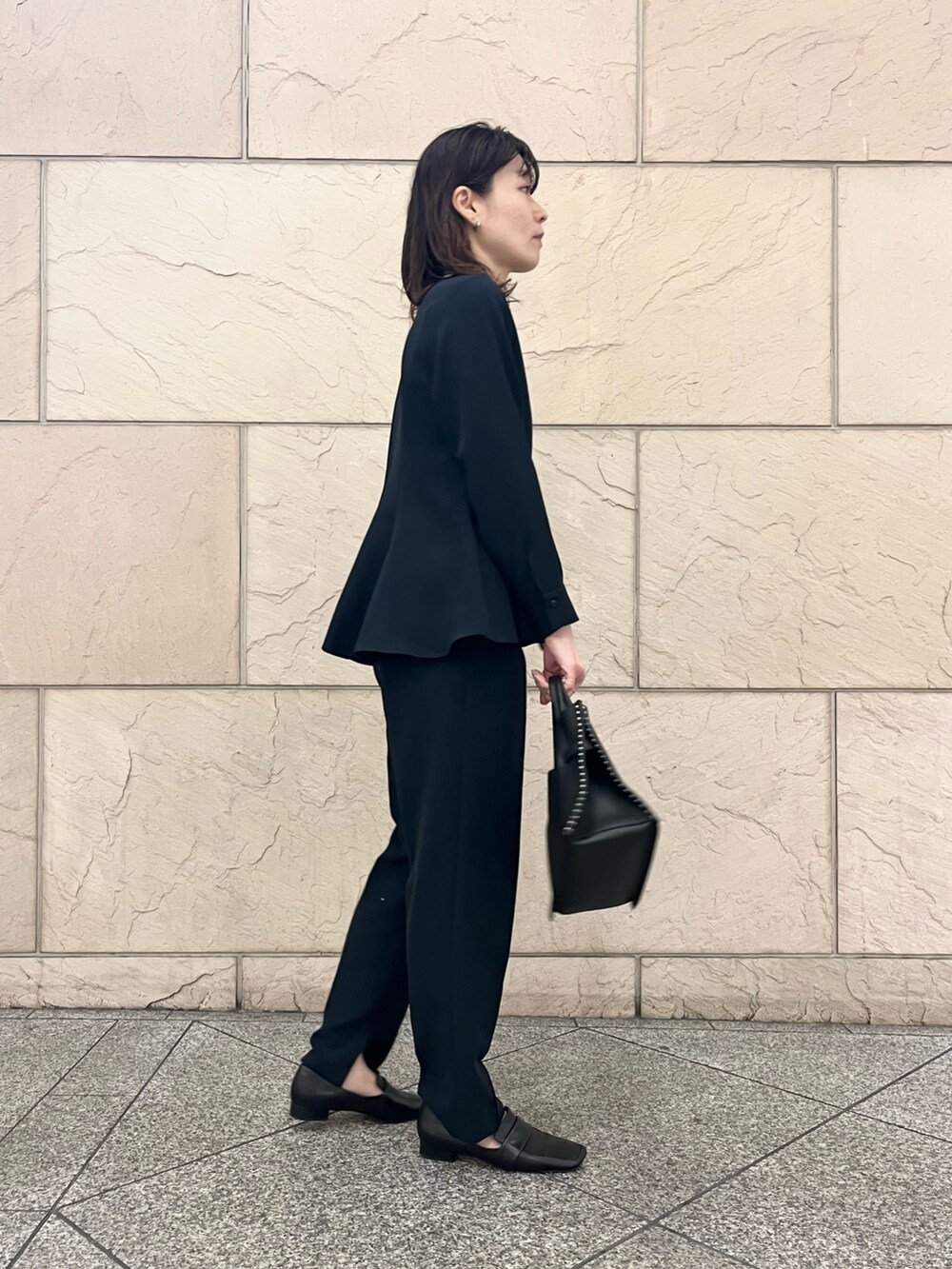 ブラック系のショルダーバッグ、ブラック系のその他シューズ、ブルー系のセットアップを着用したレディースの冬コーディネートの3枚目の写真