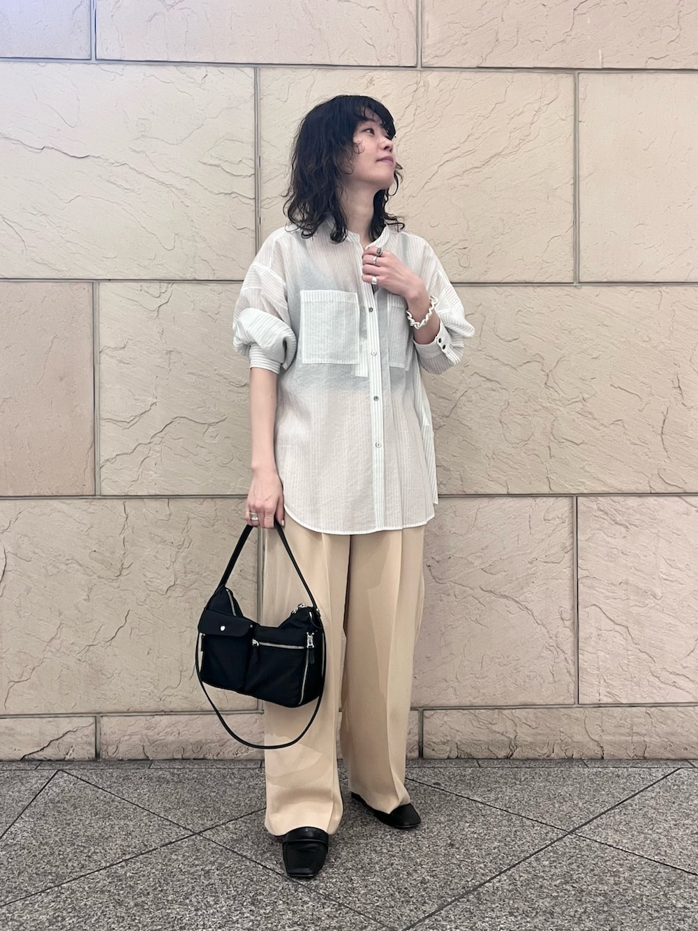 ホワイト系のシャツ/ブラウス、ベージュ系のその他パンツ、ブラック系のショルダーバッグを着用したレディースの春コーディネートの2枚目の写真