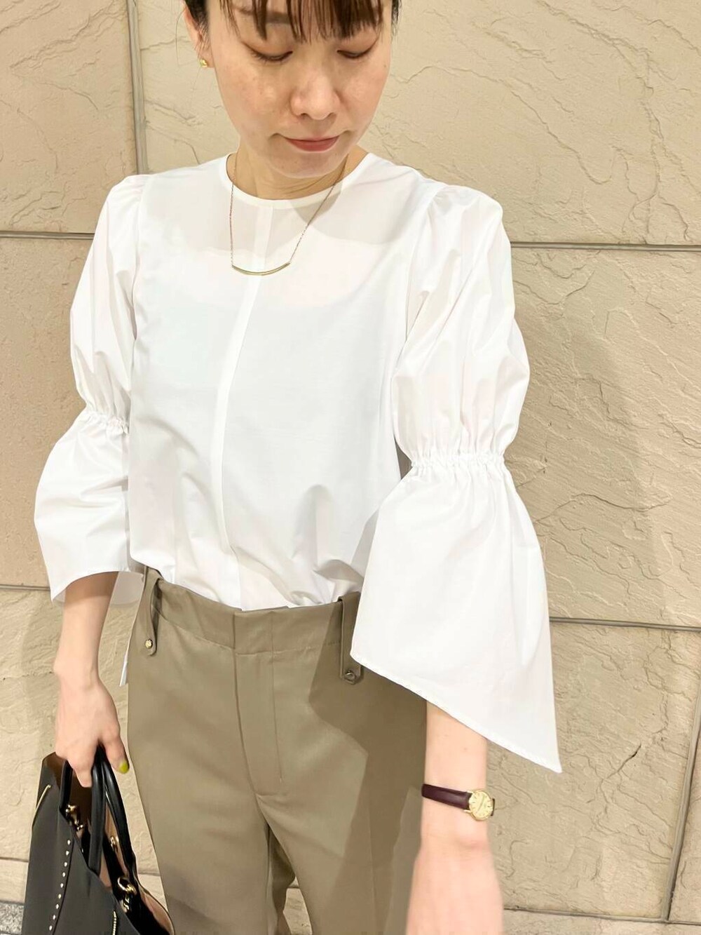 ブラック系のパンプス、ベージュ系のその他パンツ、ホワイト系のノーカラージャケットを着用したレディースの冬コーディネートの2枚目の写真