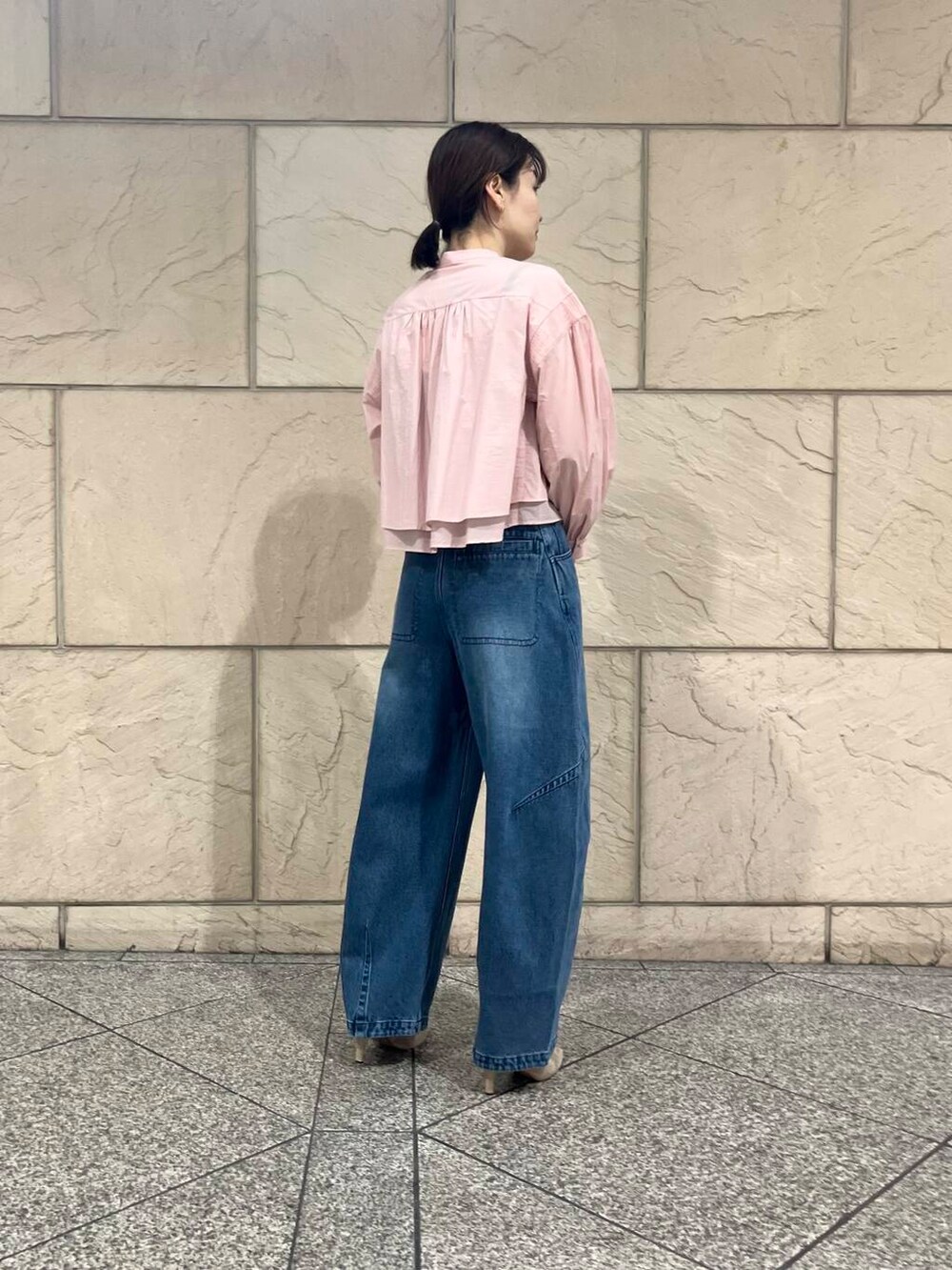 ブラウン系のパンプス、ピンク系のシャツ/ブラウス、ブルー系のデニムパンツを着用したレディースの冬コーディネートの3枚目の写真