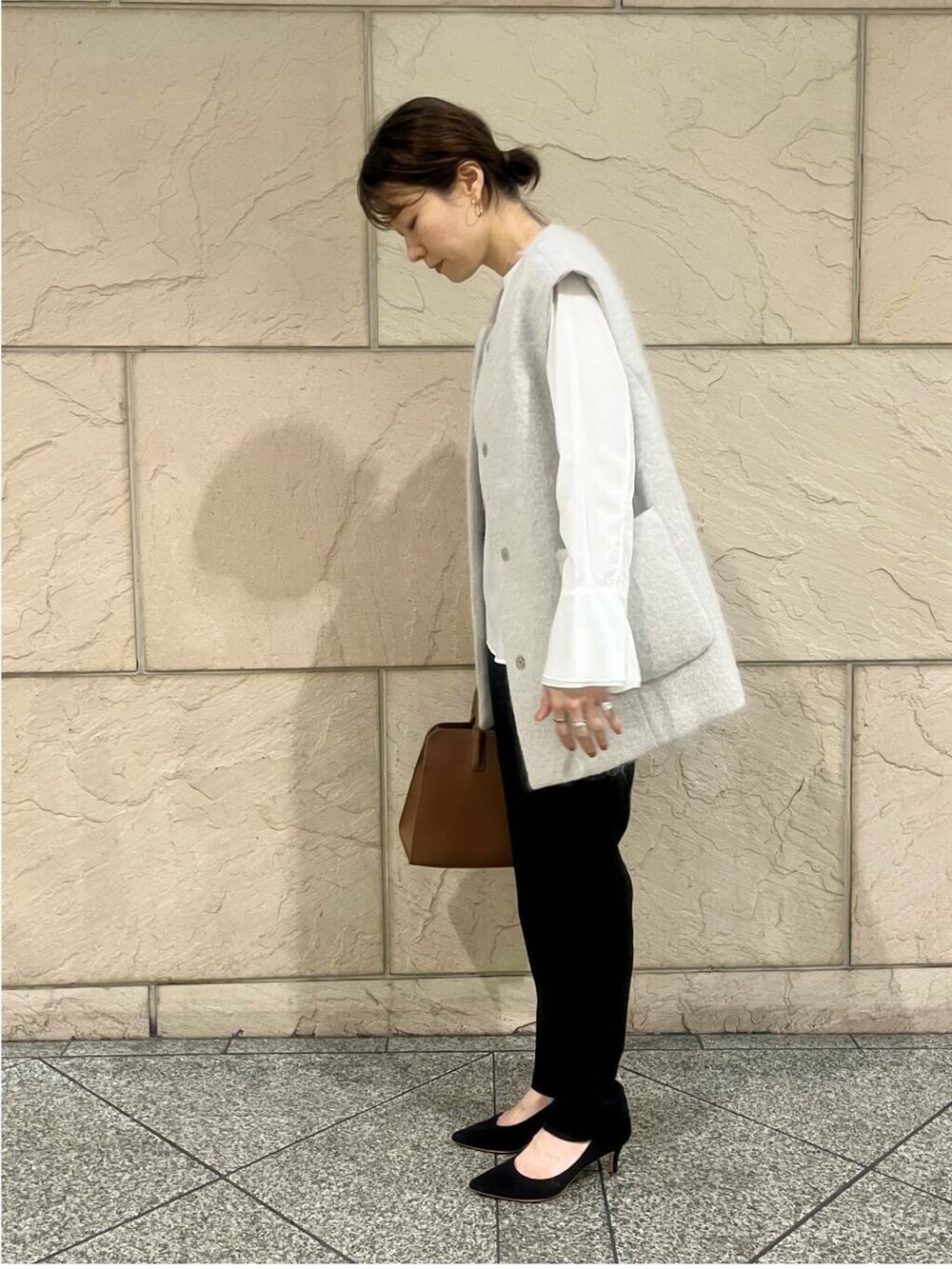 ホワイト系のシャツ/ブラウス、ブラウン系のハンドバッグ、ベージュ系のその他アウターを着用したレディースの秋コーディネートの2枚目の写真