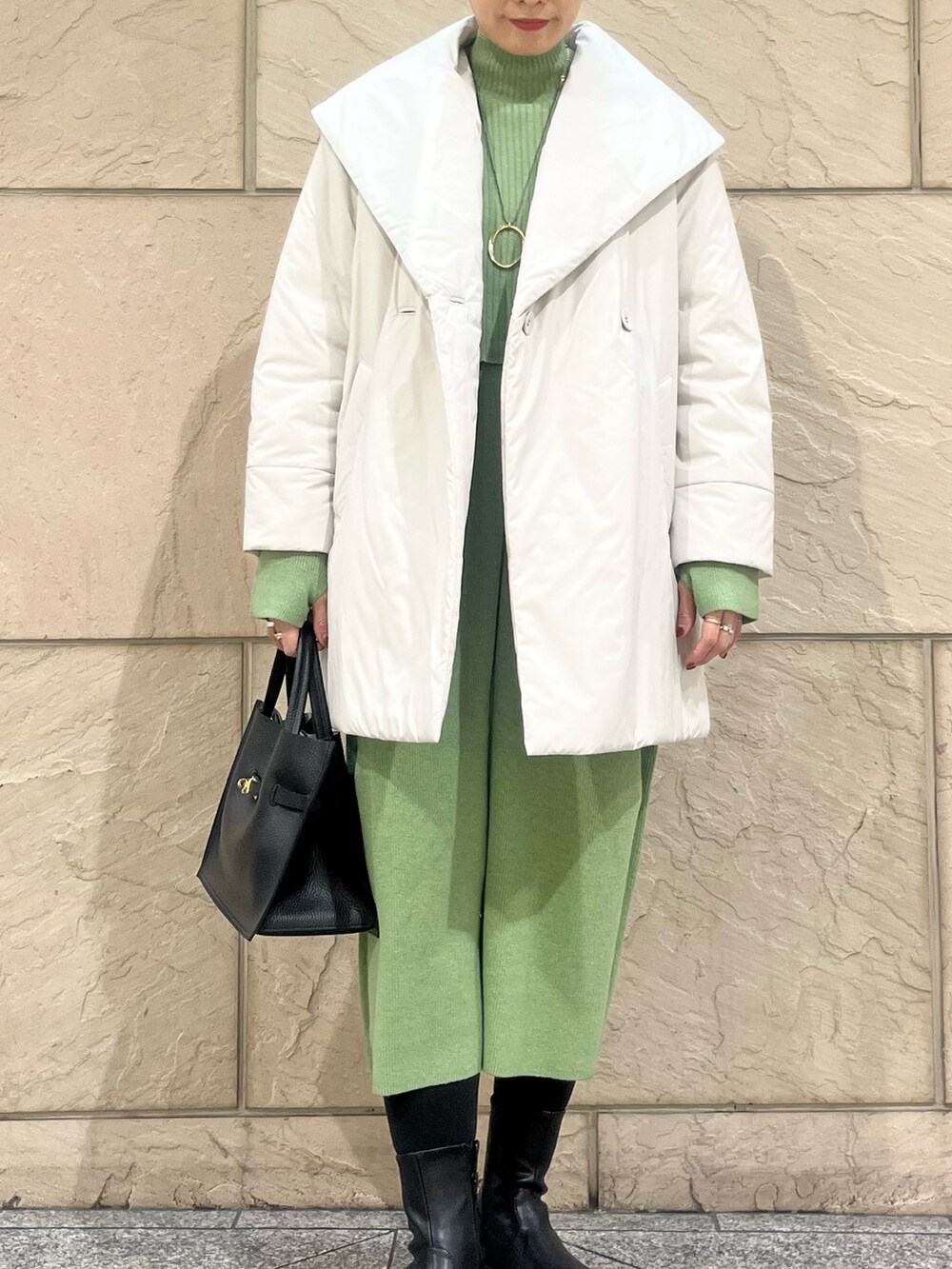 グリーン系のワンピース、ベージュ系のダウンジャケット/コート、ゴールド系のネックレスを着用したレディースの冬コーディネートの2枚目の写真