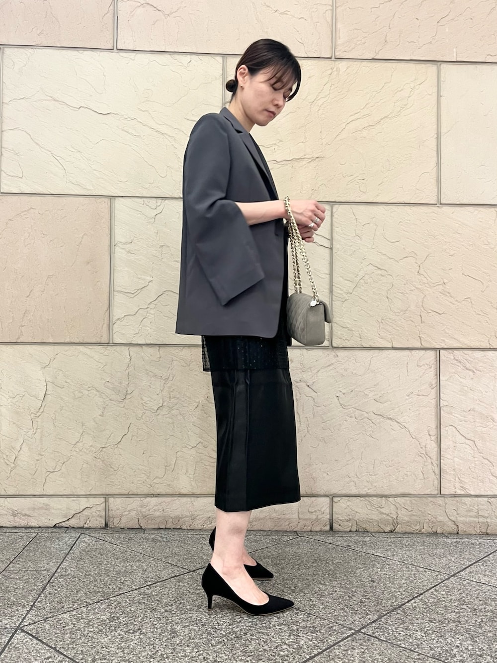 ブラック系のパンプス、グレー系のその他アウター、ベージュ系のバッグを着用したレディースの夏コーディネートの2枚目の写真