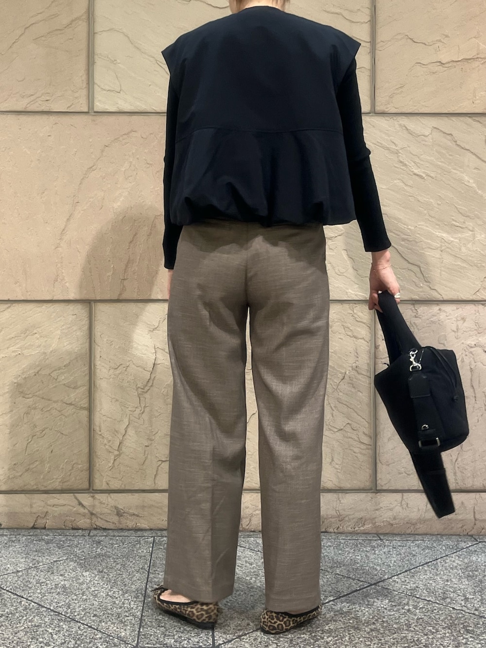ブラック系のショルダーバッグ、ベージュ系のその他パンツ、ブラック系のベストを着用したレディースの秋コーディネートの3枚目の写真