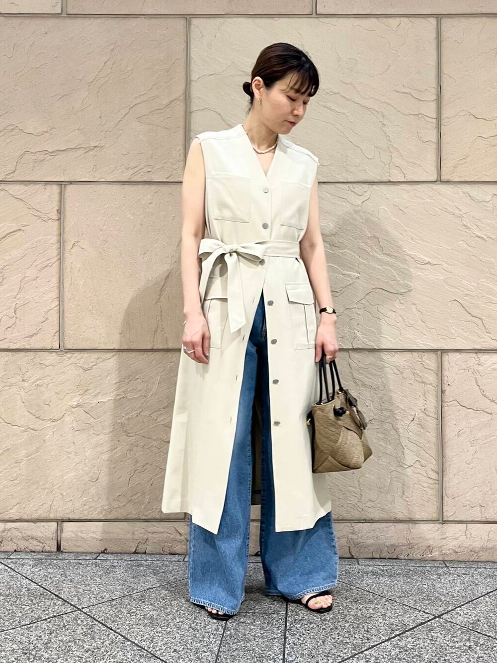 ベージュ系のワンピース、ブルー系のデニムパンツ、ベージュ系のネックレスを着用したレディースの春コーディネートの6枚目の写真