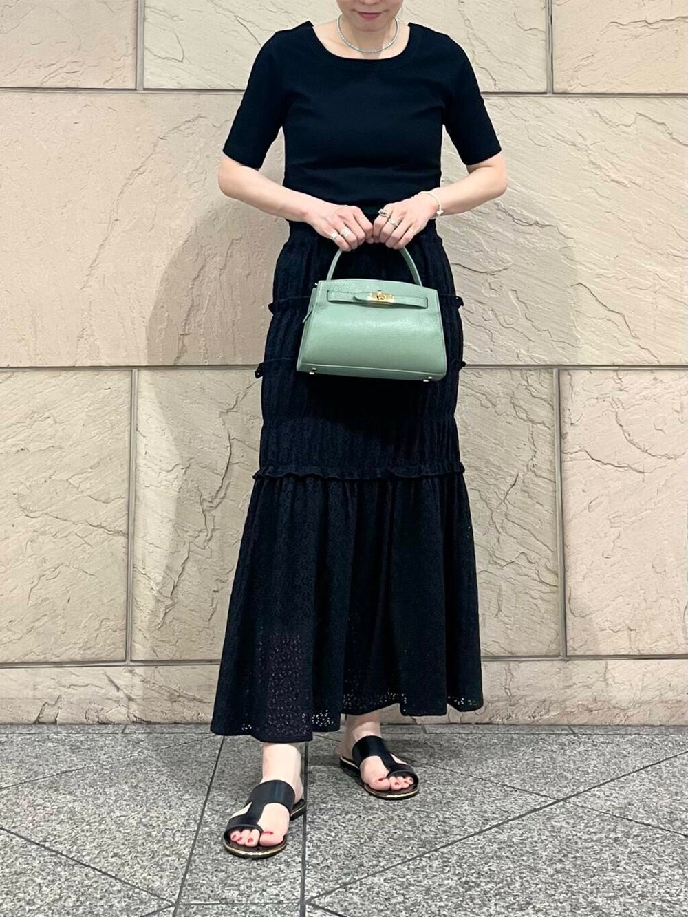 グリーン系のハンドバッグ、ブラック系のTシャツ/カットソーを着用したレディースの夏コーディネートの5枚目の写真