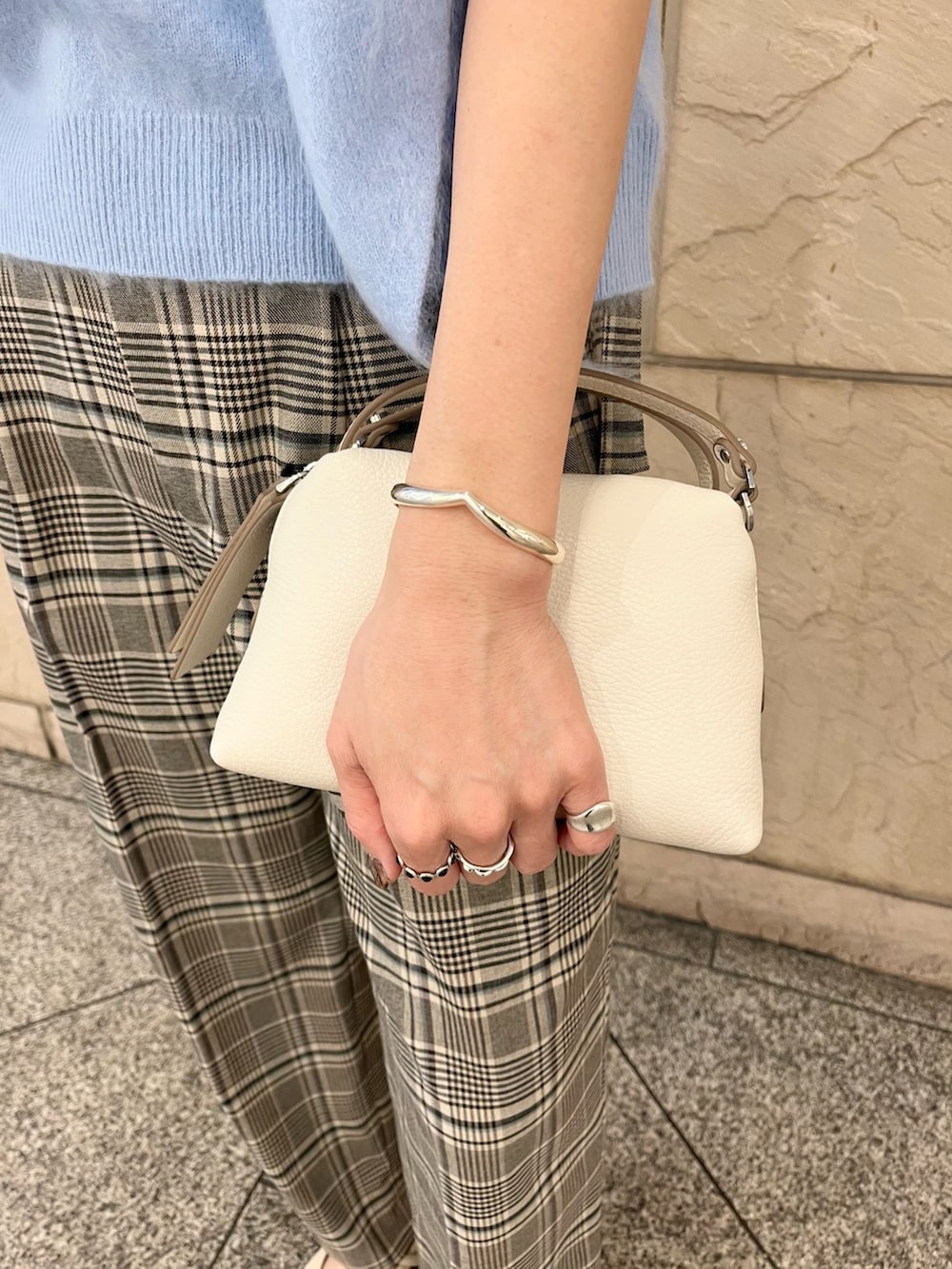 ブルー系のニット/セーター、ホワイト系のショルダーバッグ、ベージュ系のその他パンツを着用したレディースの秋コーディネートの4枚目の写真