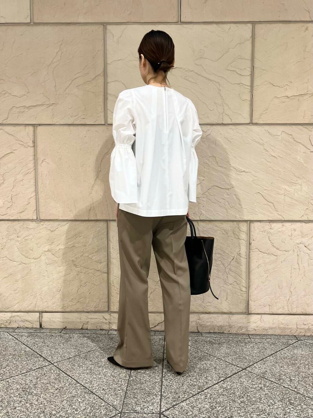 ブラック系のパンプス、ベージュ系のその他パンツ、ホワイト系のノーカラージャケットを着用したレディースの冬コーディネートの4枚目の写真