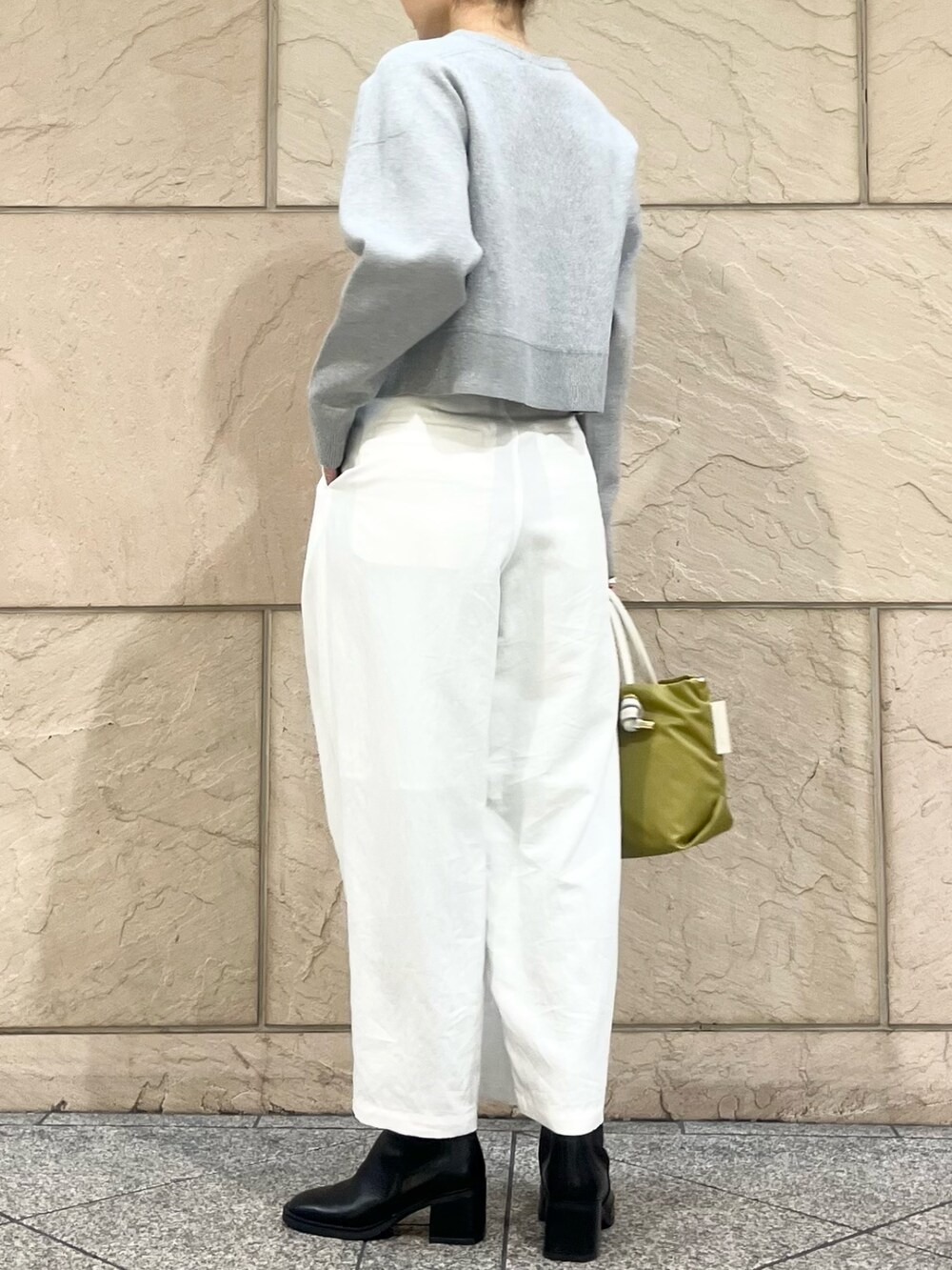 ホワイト系のその他パンツ、グリーン系のトートバッグ、グレー系のニット/セーターを着用したレディースの冬コーディネートの2枚目の写真
