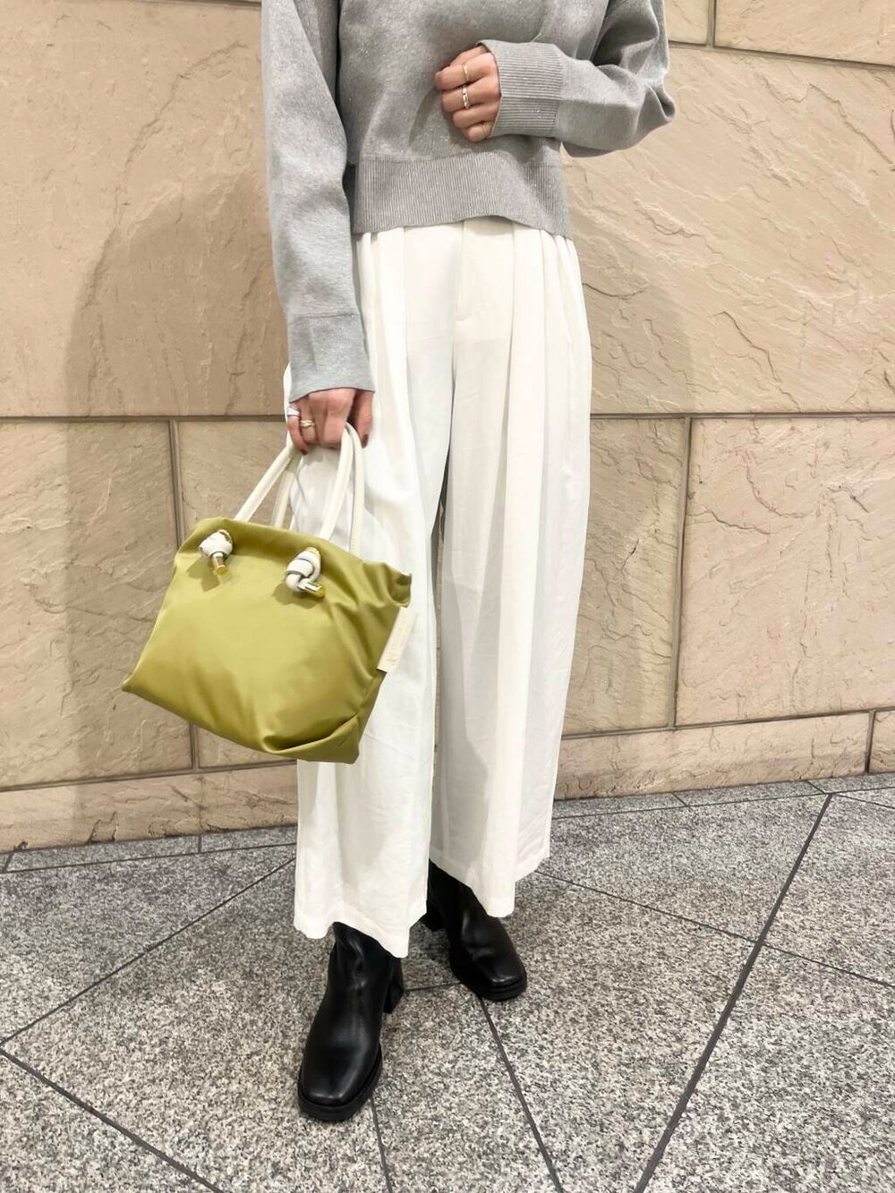 ブラック系のブーツ、グリーン系のトートバッグ、ホワイト系のその他パンツを着用したレディースの冬コーディネートの7枚目の写真