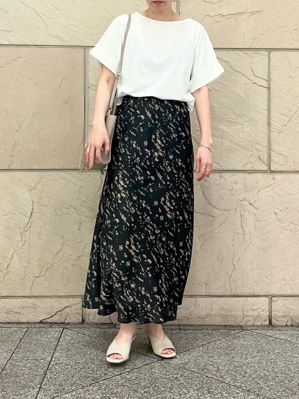 ホワイト系のTシャツ/カットソー、グレー系のハンドバッグ、ブラック系のスカートを着用したレディースの夏コーディネートの4枚目の写真