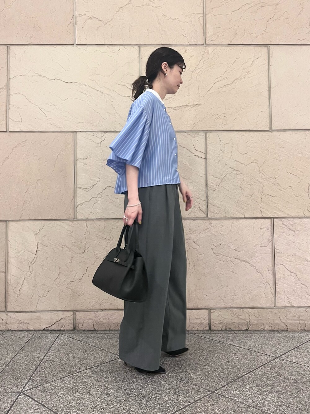 グレー系のその他パンツ、ブルー系のシャツ/ブラウス、ブラック系のパンプスを着用したレディースの春コーディネートの2枚目の写真