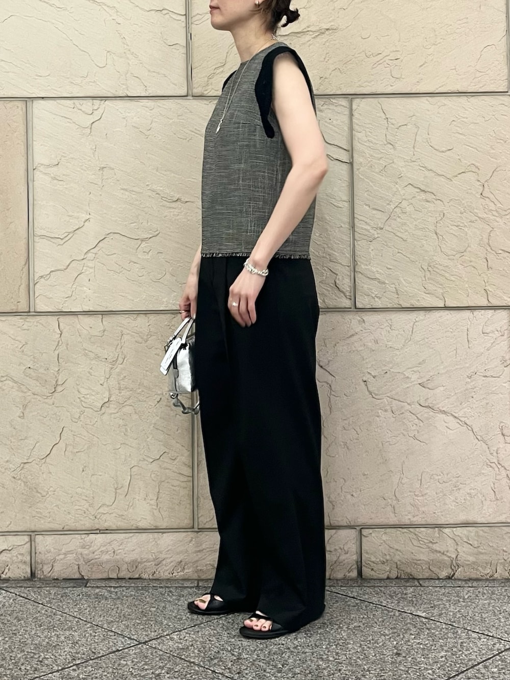 ブラック系のシャツ/ブラウス、シルバー系のハンドバッグ、ブラック系のサンダルを着用したレディースの夏コーディネートの2枚目の写真