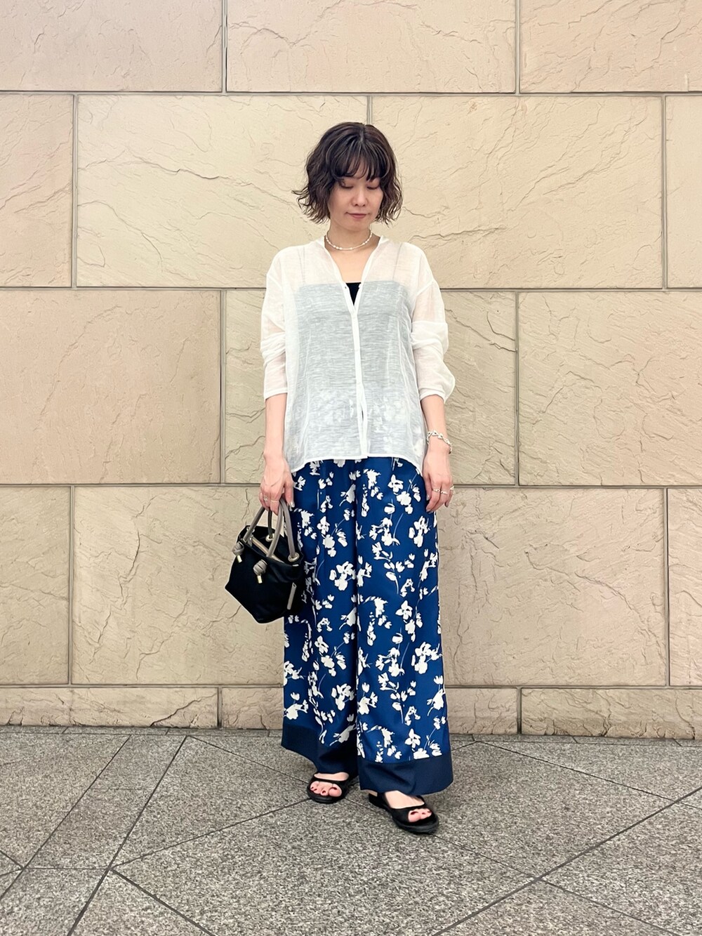 ホワイト系のシャツ/ブラウス、ブルー系のその他パンツ、ブラック系のサンダルを着用したレディースの春コーディネートの2枚目の写真