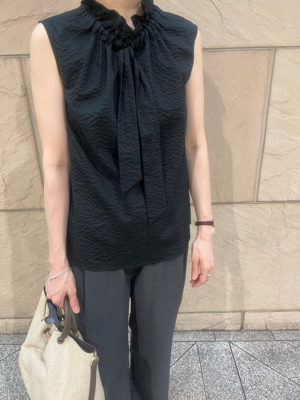 ブラウン系のハンドバッグ、ブラック系のサンダル、ブラック系のシャツ/ブラウスを着用したレディースの夏コーディネートの4枚目の写真