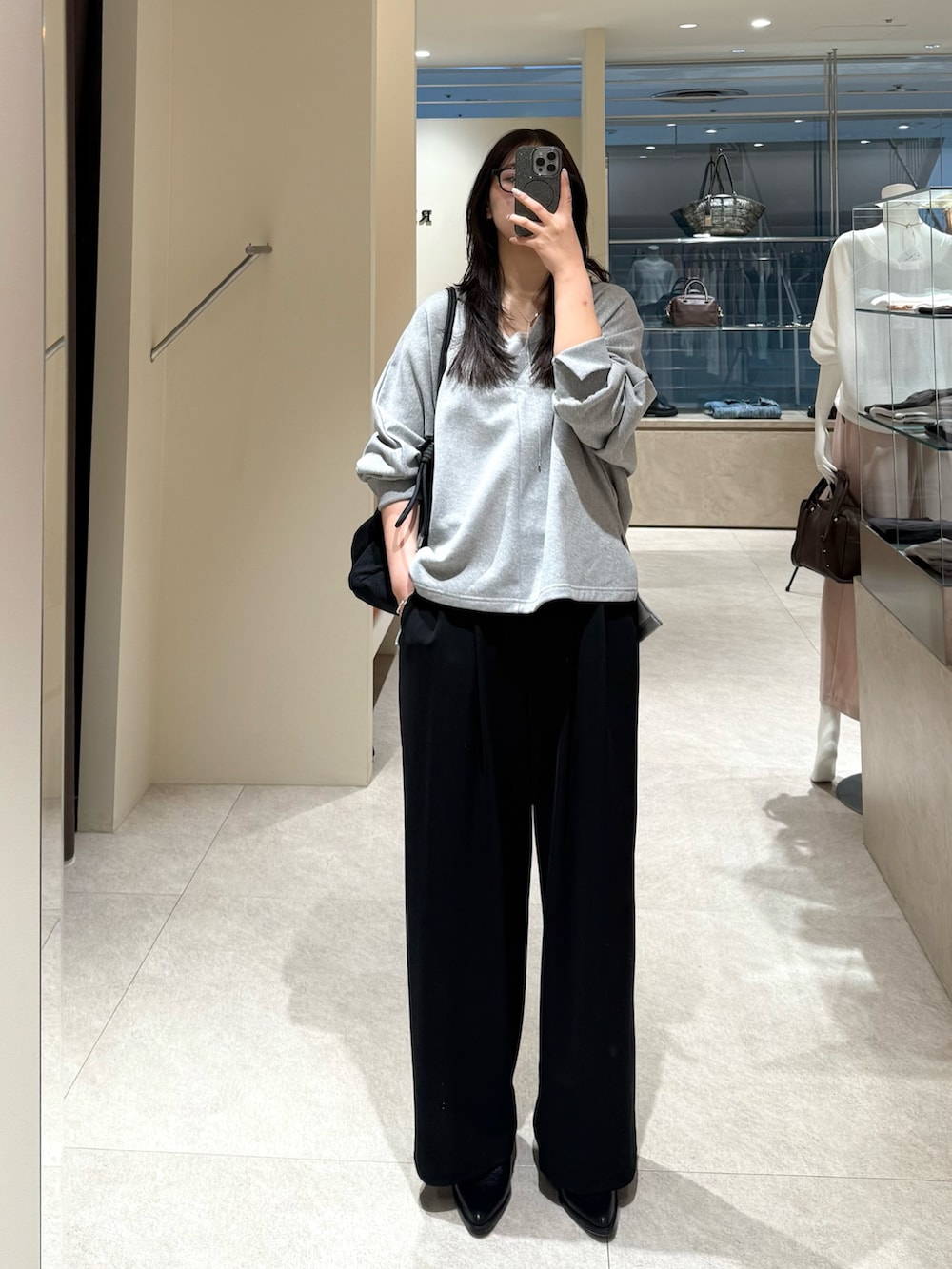 グレー系のスウェット、ブラック系のその他パンツ、ブラック系のトートバッグを着用したレディースの春コーディネートの3枚目の写真