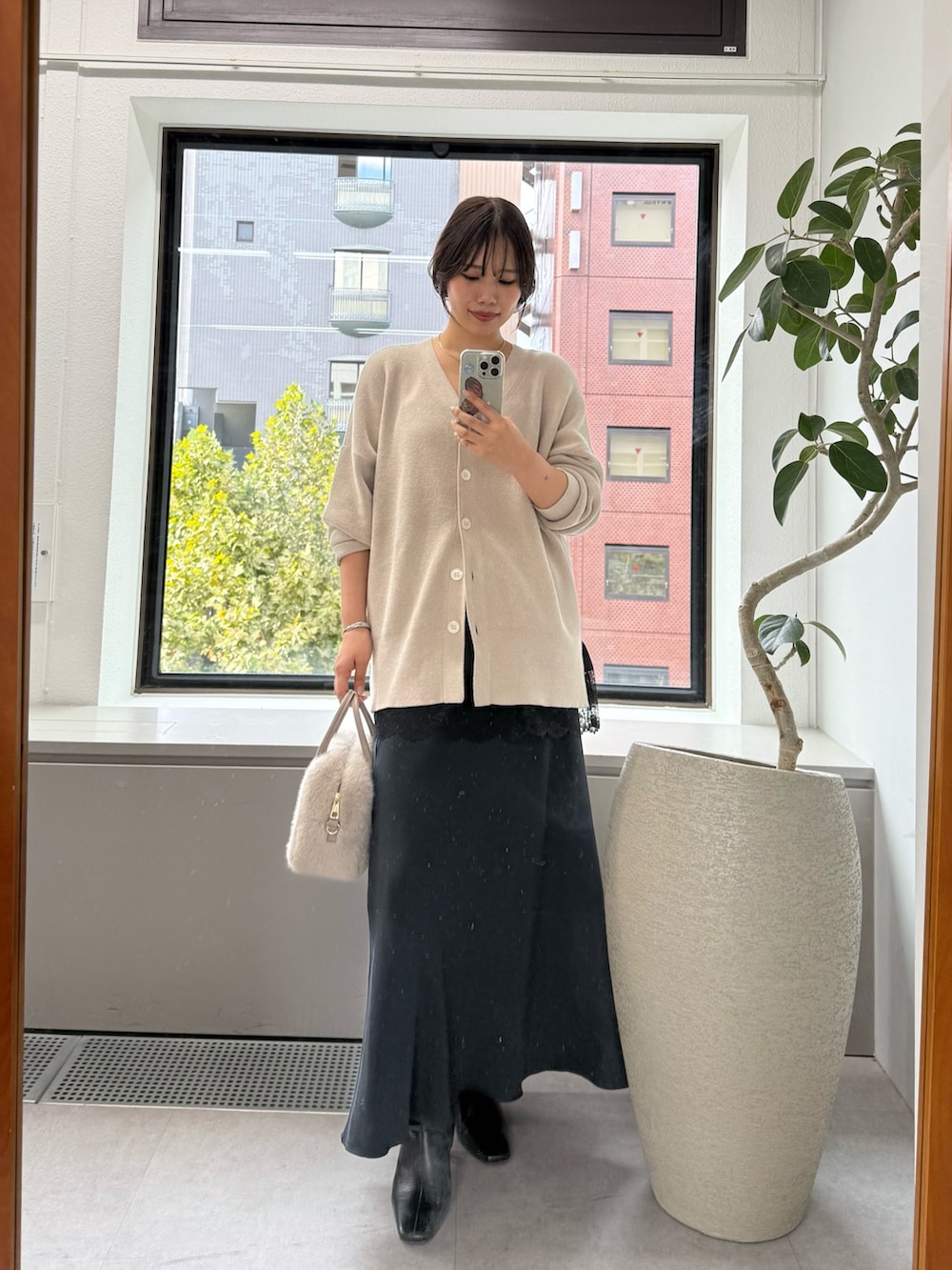 ホワイト系のニット/セーター、ブラック系のスカート、ブラック系のキャミソールを着用したレディースの秋コーディネートの5枚目の写真