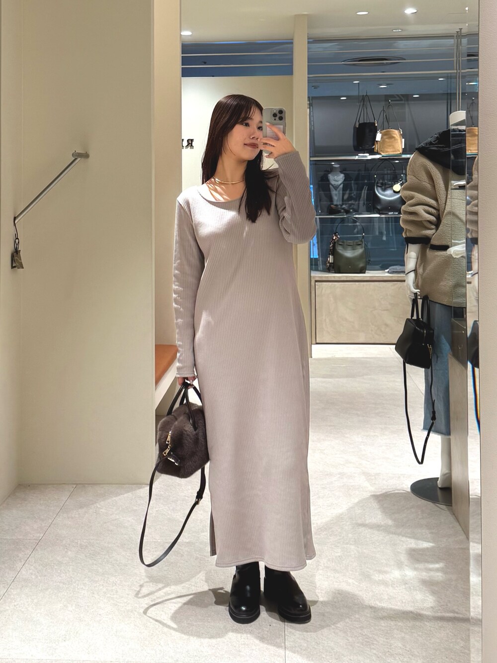 ベージュ系のワンピース、ブラウン系のボストンバッグを着用したレディースの冬コーディネートの4枚目の写真