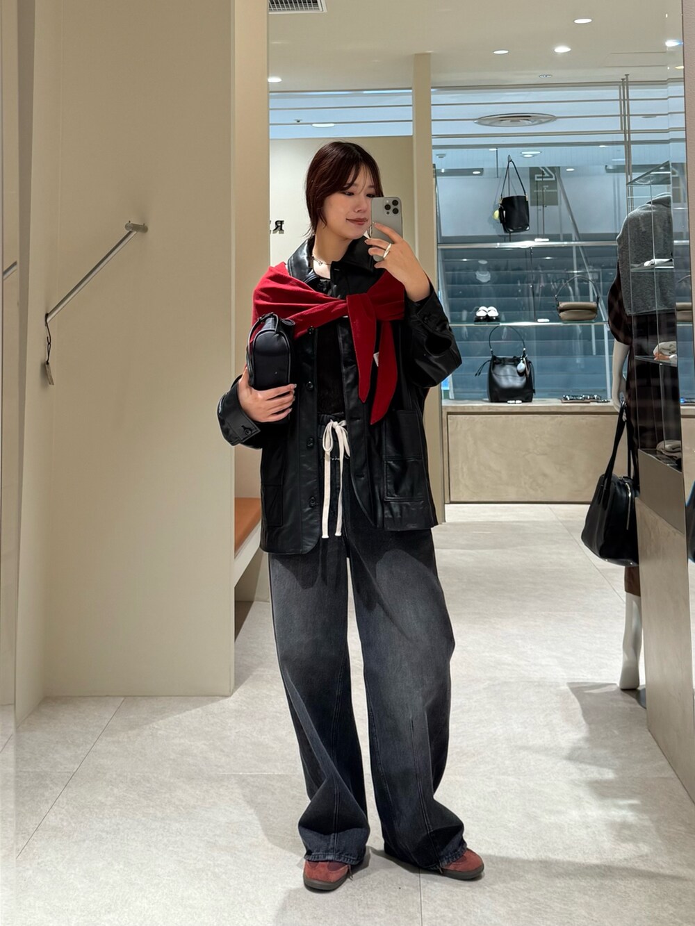 ブラック系のデニムパンツ、ブラック系のその他アウターを着用したレディースの秋コーディネートの3枚目の写真